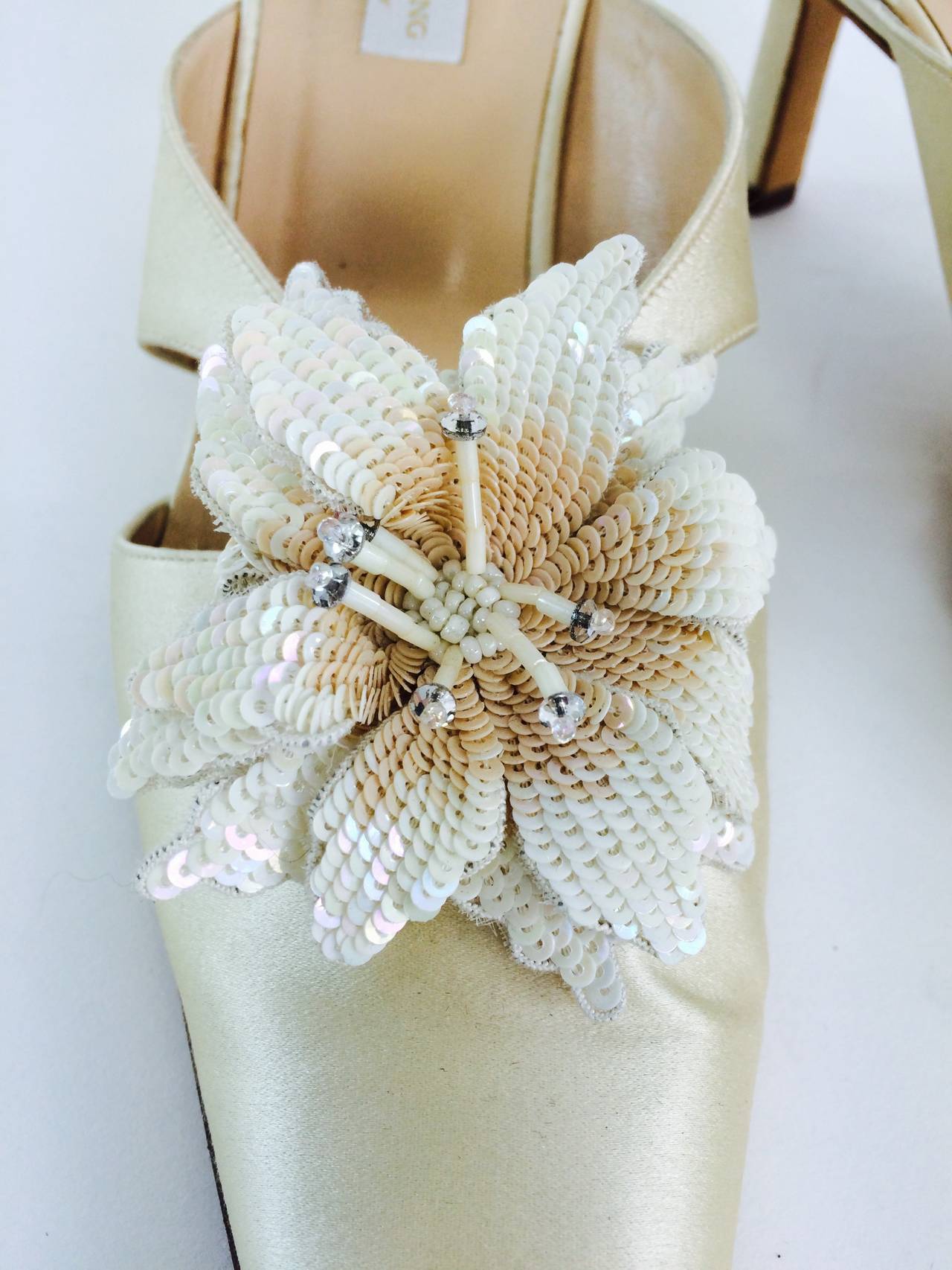 Champagne silk highheel mules with sparkling sequin and beaded flower appliques make these shoes magic...Perfect for a wedding...Lined in soft leather...Marked size 8 1/2...There is one tiny abrasion to the silk, like a light mark, on the left shoe