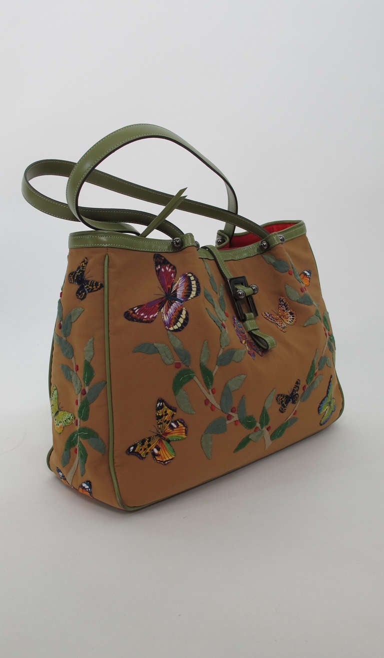 Renaud Pellegrino Paris, applique bag with green leather trims.....Cafe au lait bag is hand appliqued with brightly coloured butterflies and berried greenery...Double leather handles...Gold metal hardware...Lined in red cotton, with a single center
