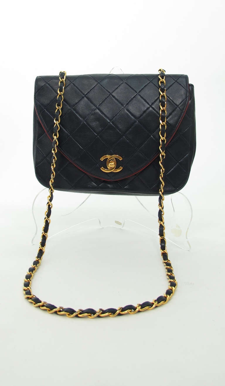 Vintage Chanel navy blue flap shoulder bag, soft lambskin leather, the flap edge is trimmed in dark red leather...Curved flap with turn lock closure...embroidered double C's on the inside of flap...Inside zipper compartment...Shoulder leather/chain