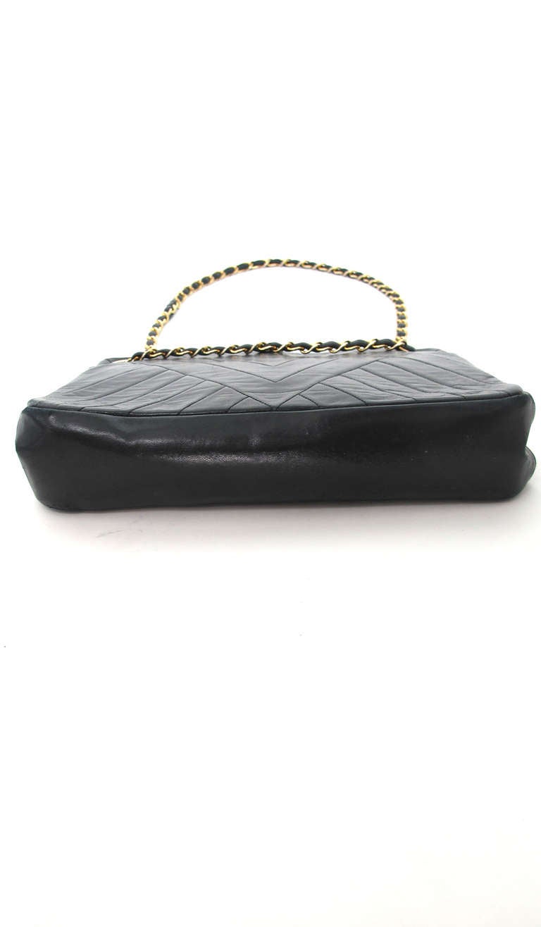 Vintage Chanel black chevron quilted chain handbag...Soft black lambskin leather with a small gold Chanel logo at the upper front of bag...Inside there are open compartments at either side of the center compartment, which has a kiss-lock frame,