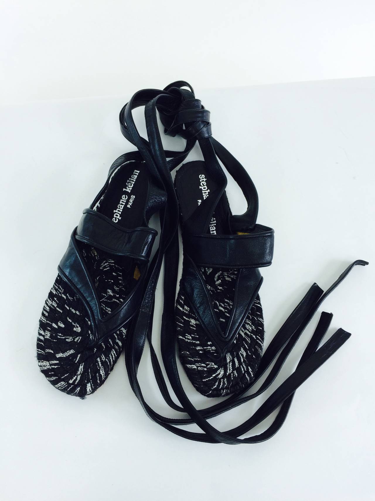 Stephane Keilan black leather & black & silver jute leg wrap espadrilles...Black thong front with leather band over the foot and  long black leather ties...Unworn marked size 38