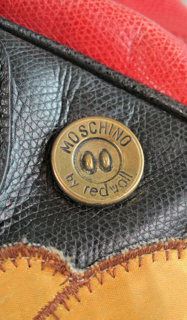 Rare to find, large size 1980s Moschino Redwall applique charm bowler handbag...Red and black leather handbag is appliqued with Moschino labels, keys, hearts, a large teddy bear, name an iconic Moschino logo & it's probably here!  Double black