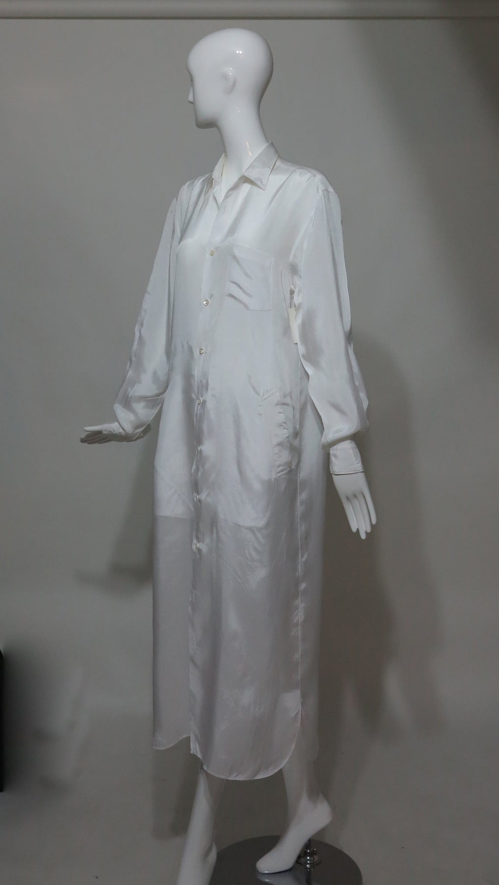 Comme des Garcons sheer white (feels like) nylon button front coat 1990s...Long sleeve coat buttons at the front and at the banded cuffs, single chest pocket and angled banded hip pockets, shirttail hem...Unlined...Fits like a S-M

Please check