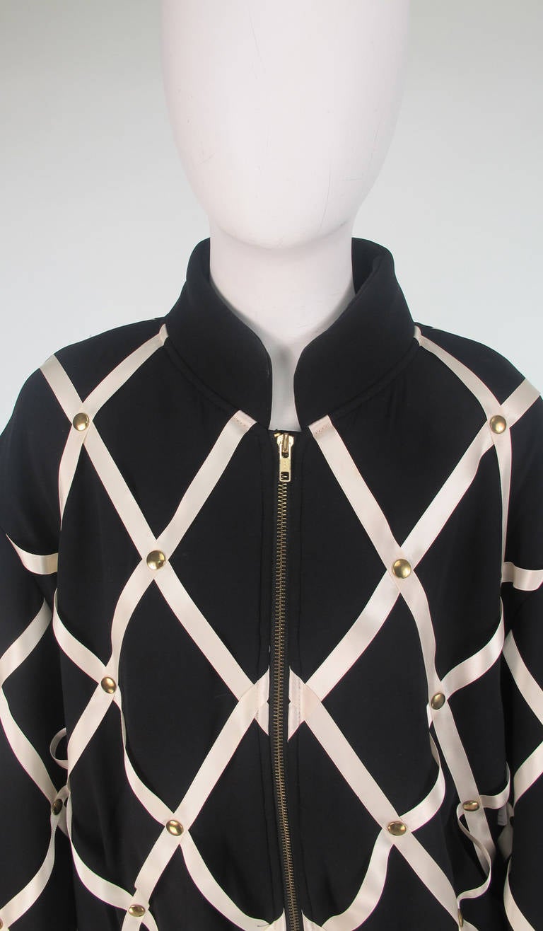 Add a big post card or a note to this pin board jacket & enter into the spirit of Franco Moschino...Black crepe (feels like silk) bomber style jacket has appliqued white satin ribbon trim with brass 
