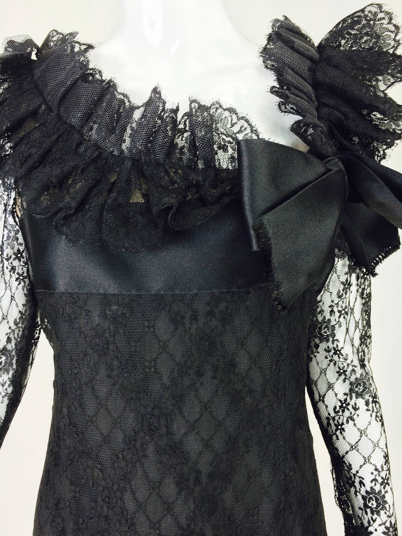 Bill Blass black lace ruffle & bow trimmed cocktail dress 1970s...Chic little black dress...Black lace semi fitted dress with long sheer sleeves, empire bodice and a neckline and hem trimmed in a deep lace ruffle accented with wide black silk ribbon