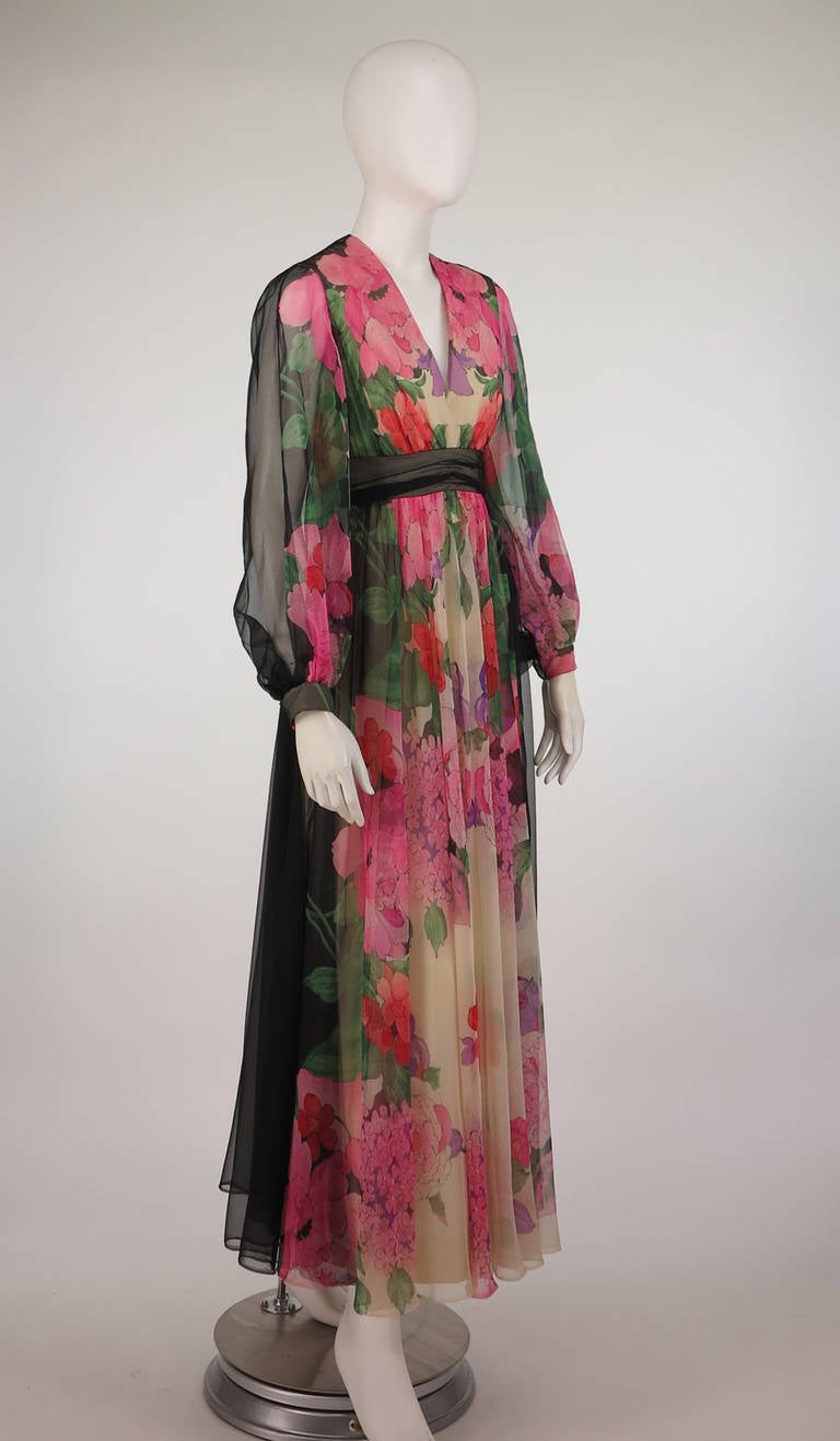 Mollie Parnis Boutique, designed by Morty Sussman...From the 1970s...Deep V neckline maxi dress, with long full sleeves that are gathered into banded cuffs...Th maxi skirt is semi full and is gathered into an under bust band that forms the sightly