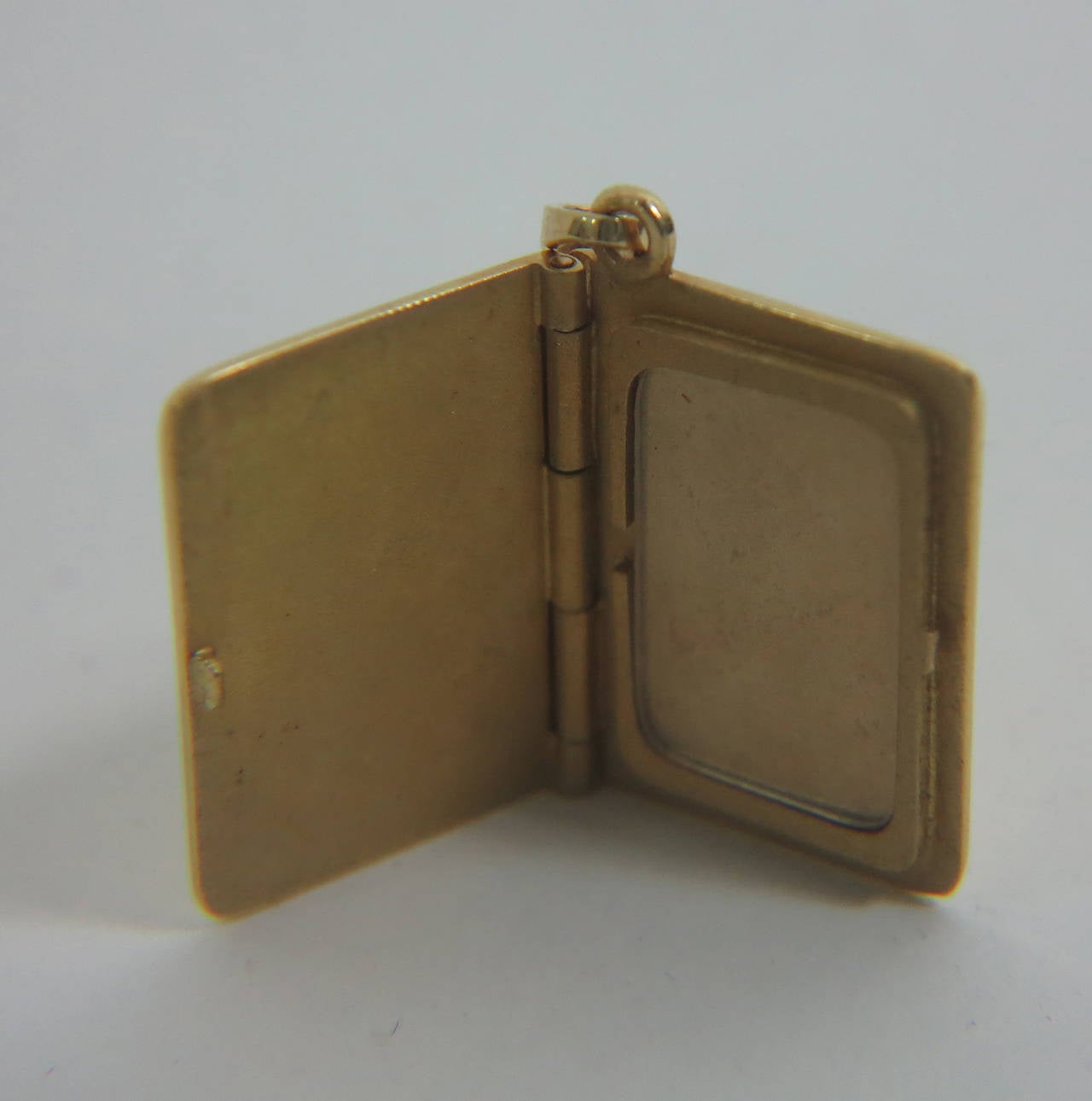 Cartier 18K {750} gold United States passport photo holder charm...Opens to hold a photograph...In very good condition, with some scratches as you would expect from use.

Measurements are:
Width .625
Height .875
Width open 1