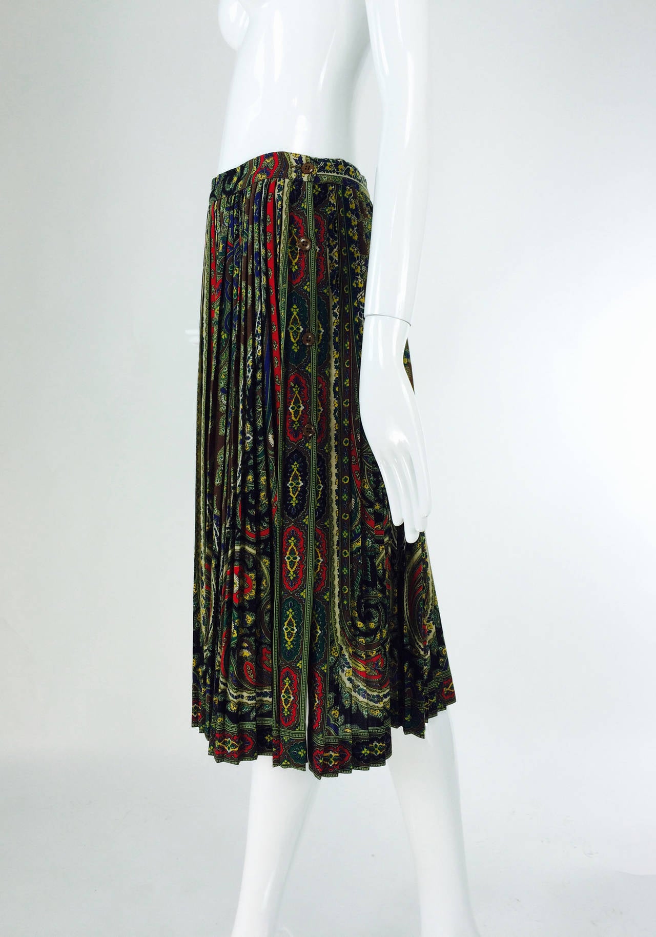 Kenzo paisley pleated side button skirt 1970s...Richly detailed wool challis paisley print skirt in greens & cocoas with accents of red...This skirt is a perfect layering piece that will add interest to any wardrobe...Banded waist skirt (sits at the