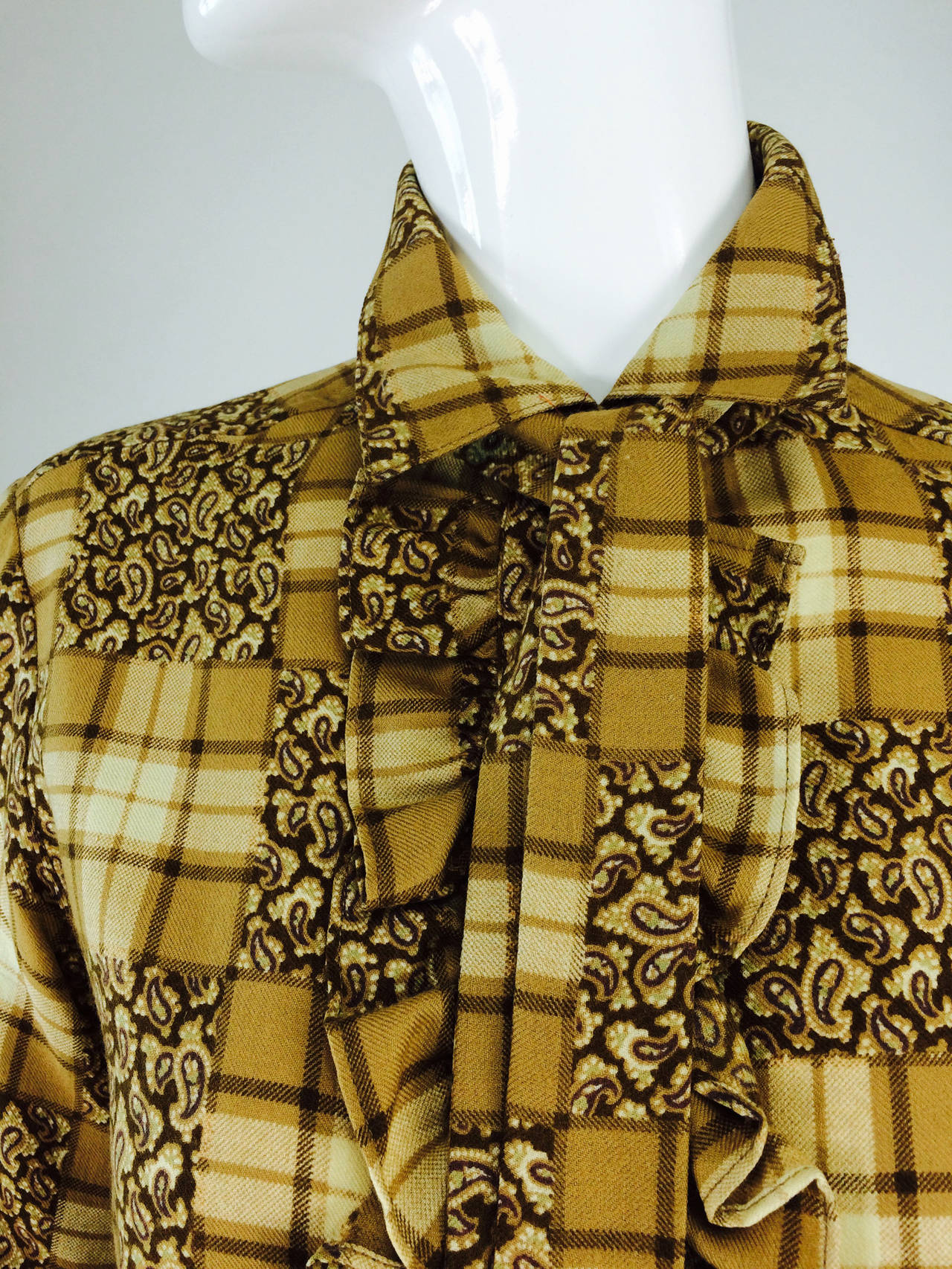 Yves St Laurent Rive Gauche tan plaid ruffle front blouse 1970s...Fine, soft wool challis, almost feels like cotton flannel...Plaid print with squares of paisley throughout...The blouse is long sleeved with button cuffs, ruffles at either upper side