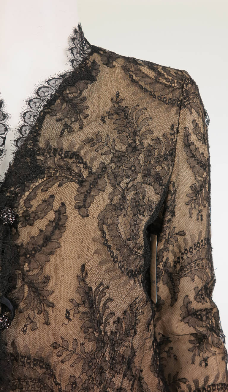 1930s black Chantilly lace blouse...Made from an older piece of lace, probably 1800s...Sheer lace is lined in nude silk...Long sleeve blouse with scalloped facings, hem and cuffs...Closes with glittery black buttons and loops at the front...Fits