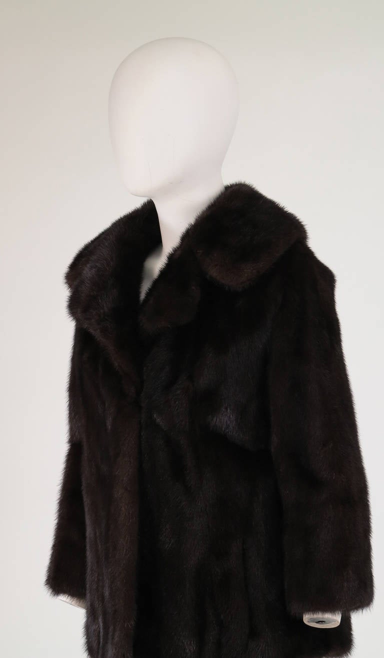 Dark mink jacket from the 1960s...wide notched collar, raglan sleeves, closes at the front with fur hooks, 3/4 length sleeves, on seam front pockets, slightly flared shape...Fully lined...fits like a modern 4-6...

In excellent wearable