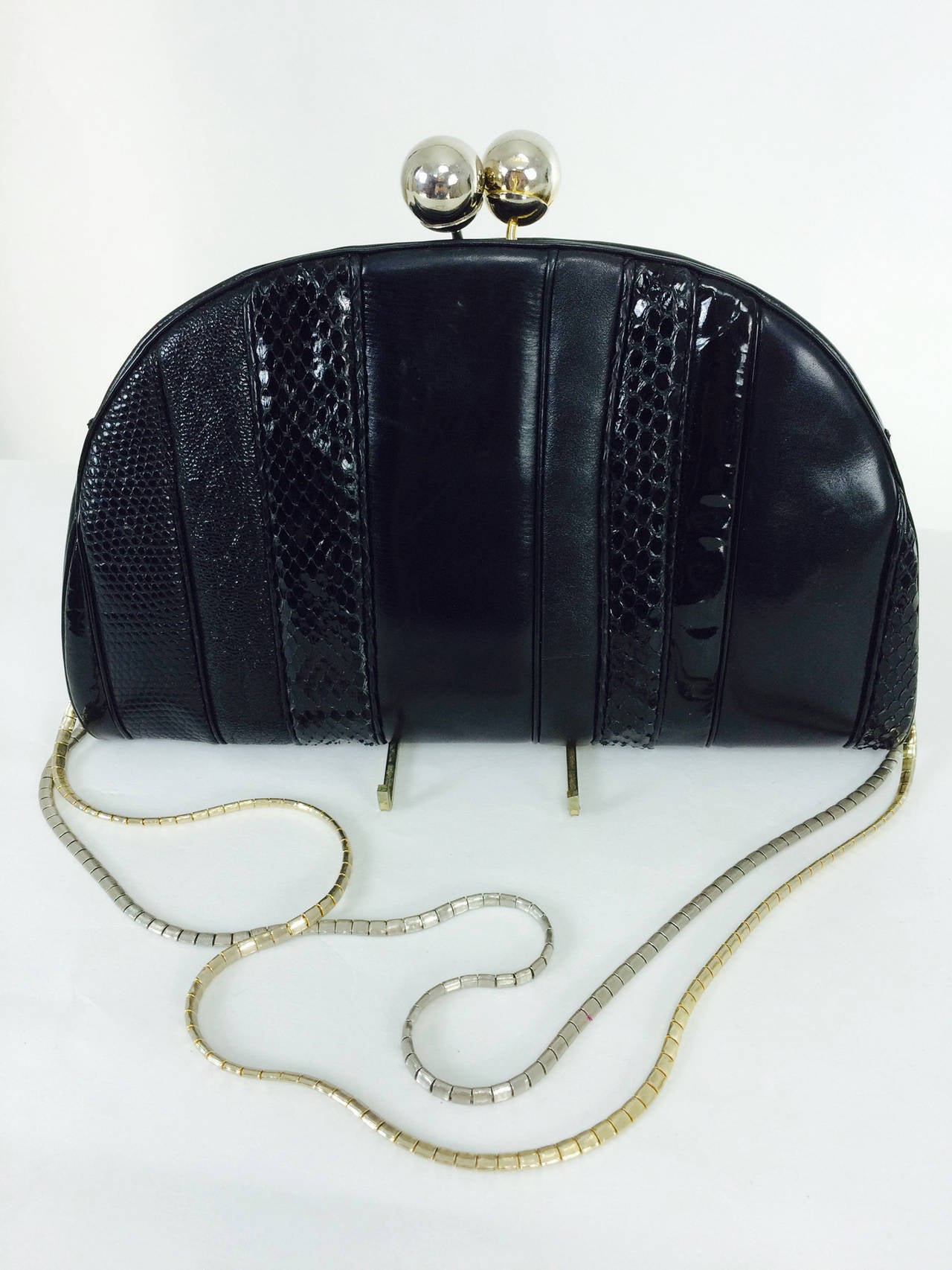 Judith Leiber black leather & snakeskin shoulder bag 1980s...Half moon shaped bag has panels of patent leather, glazed python, black lizard and mate black leather...The bag closes with two large silver balls...there is a gold and silver chain