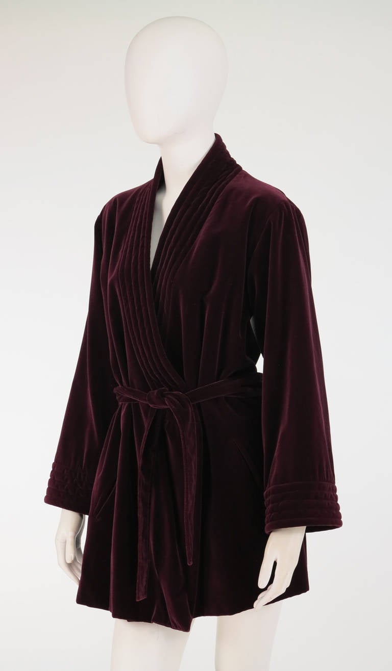 Cut like a mens Victorian smoking jacket, this 1970s Yves St Laurent garnet velvet wrap jacket is stylish with a capital 