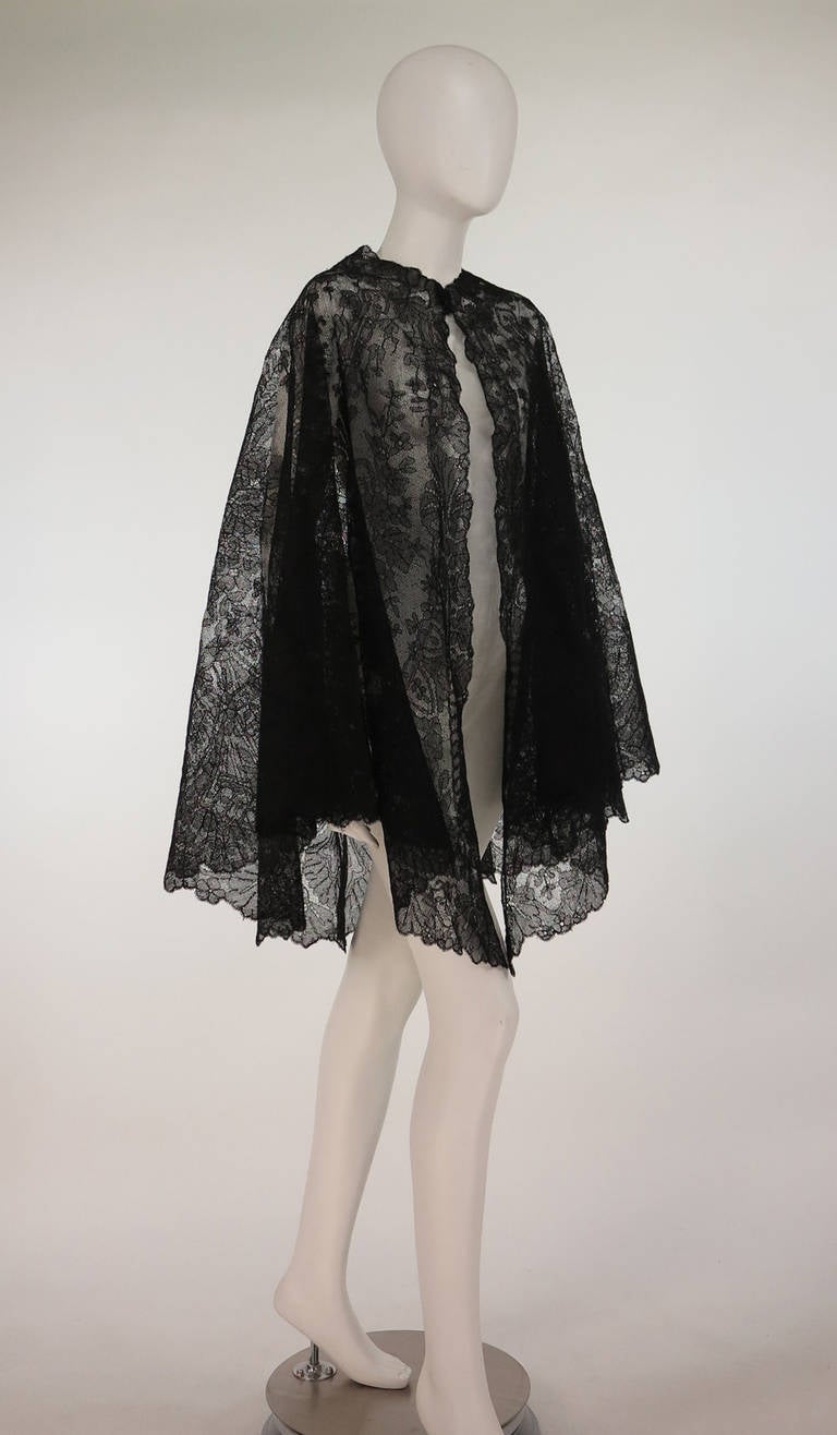 Mid 1800s bobbin lace cape from Chantilly, France...Commonly seen in the triangular shape, cape forms are much rarer to find...Shaped neckline, open front with full circular hem, a bit longer than fingertip...Black linen/silk thread...Foliate