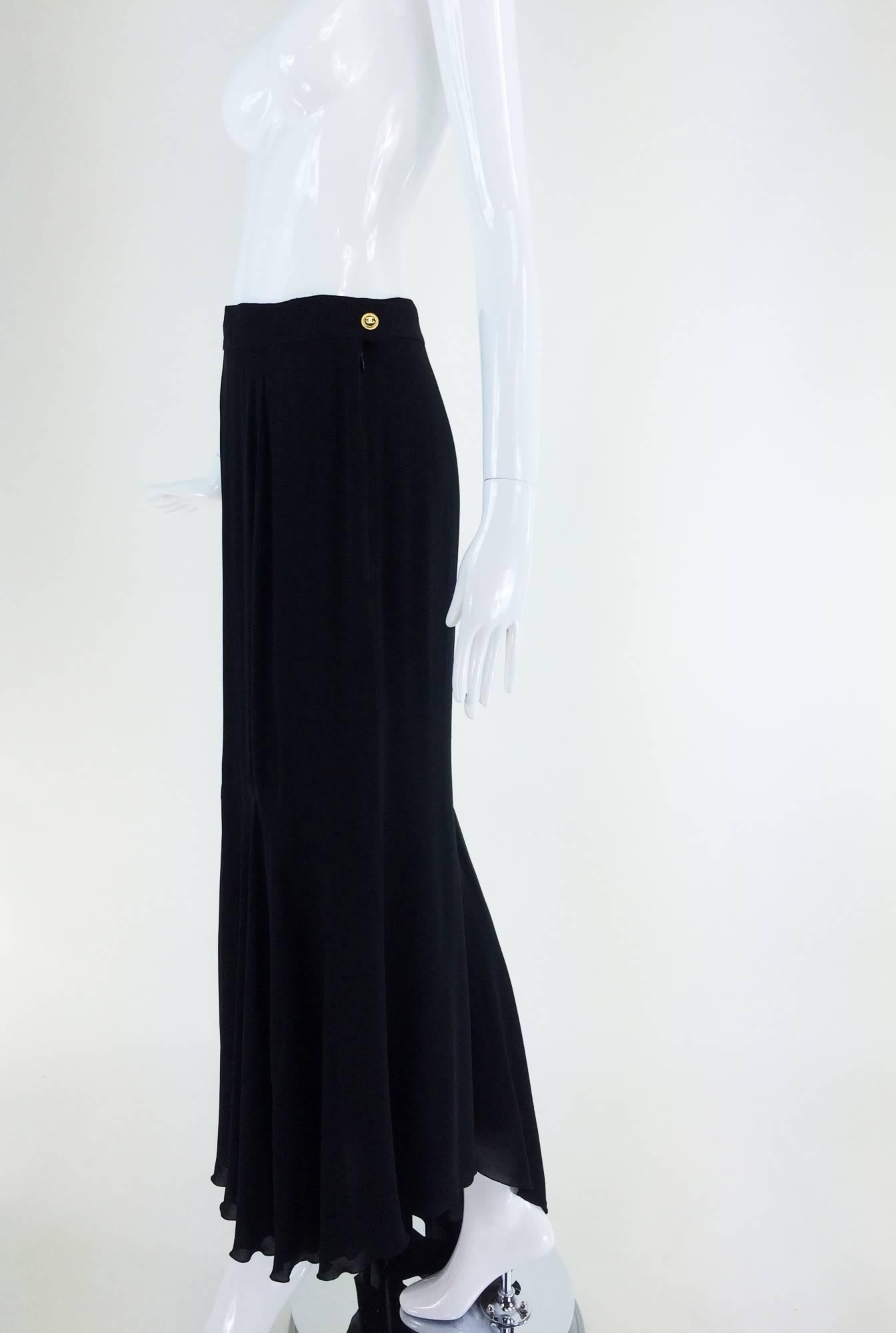 Chanel black silk chiffon evening skirt with train 1990s...Black chiffon evening skirt has a banded waist, closes with a zipper and Chanel button...Lined in black chiffon...There are a few tiny pulls at the waist...Fits like a size 4

In excellent