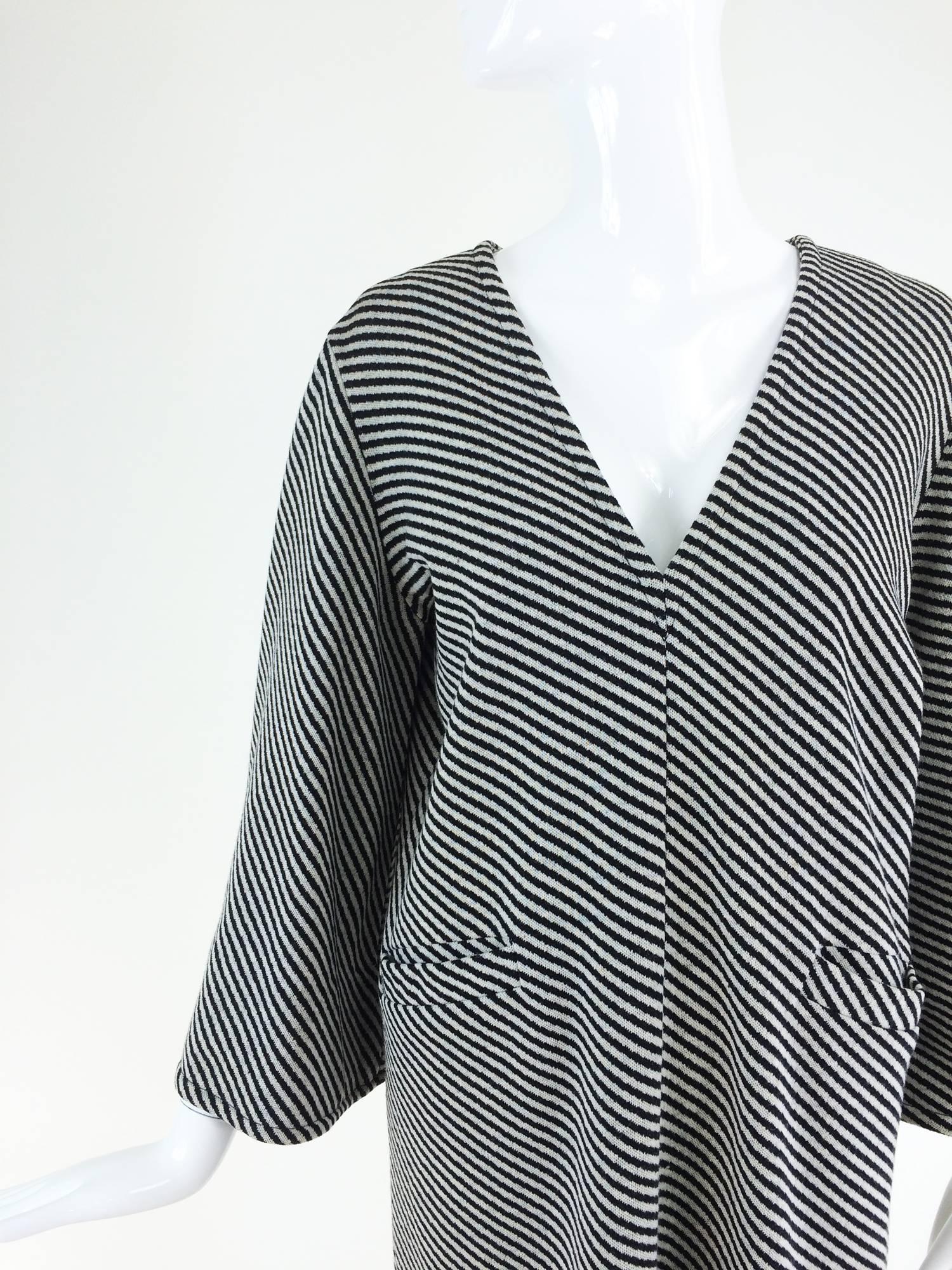 Black and white jersey knit Mod style dress from the 1960s, Rudi Gernreich for Harmon knits...V neckline dress with relaxed shoulder, long bell sleeves, shift style with angled banded pockets at the hip fronts...Unlined...Closes at the back with a