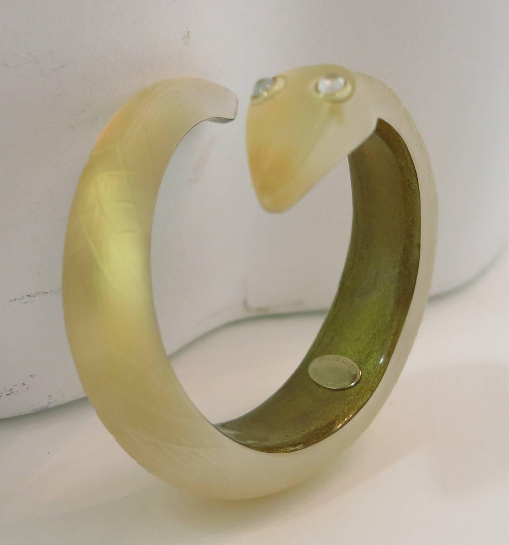 Alexis Bittar hand carved gold Lucite snake bracelet...Carved details in frosty Lucite, the center is layered with sparkly gold that adds a delicate gold simmer...The snake has bezel set moonstone inspired eyes...Fits a small-small medium 