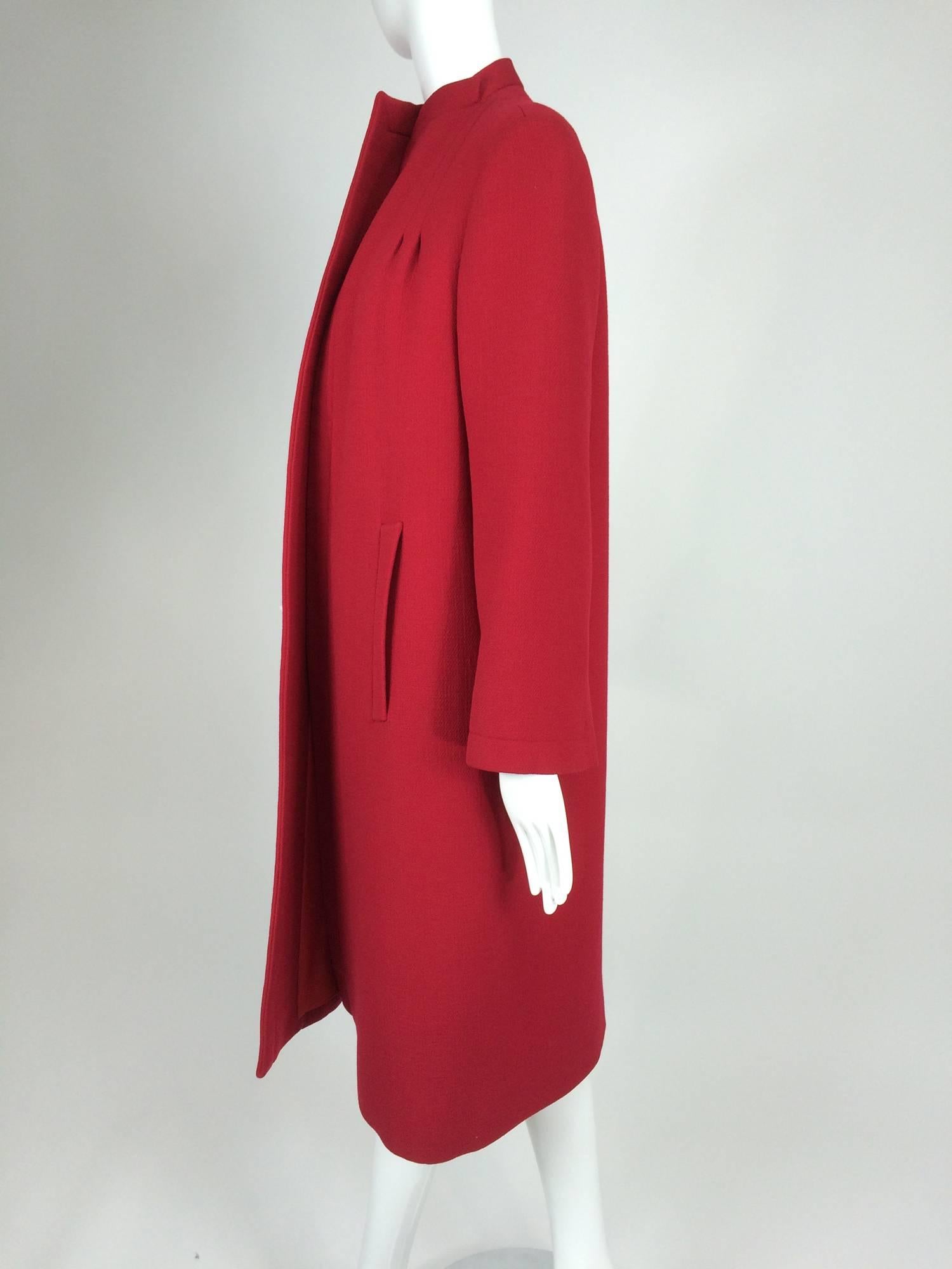 Pauline Trigere chic red wool open front coat 1950s...Beautiful cherry red wool coat from the 1950s by Pauline Trigere...Open front coat has a stand up collar, double open pleats at each shoulder front, vertical banded hip front pockets...Long