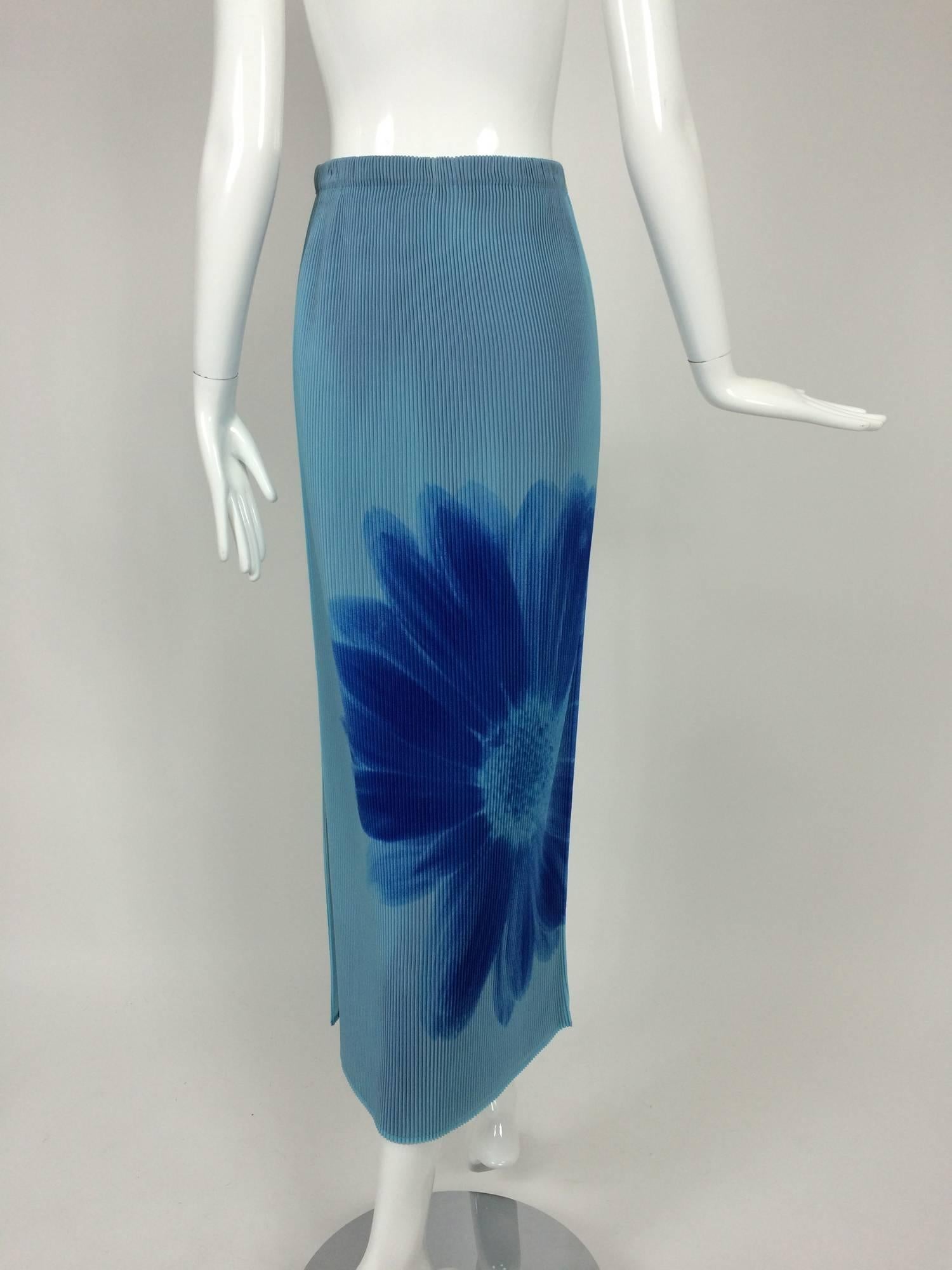 Issey Miyake layered blue pleated maxi skirt with daises...Pull on maxi skirt with narrow accordion pleating, the top layer a dusty sky blue, there is a large printed daisy at the front and back...Deep side vent...The pleated under skirt is royal