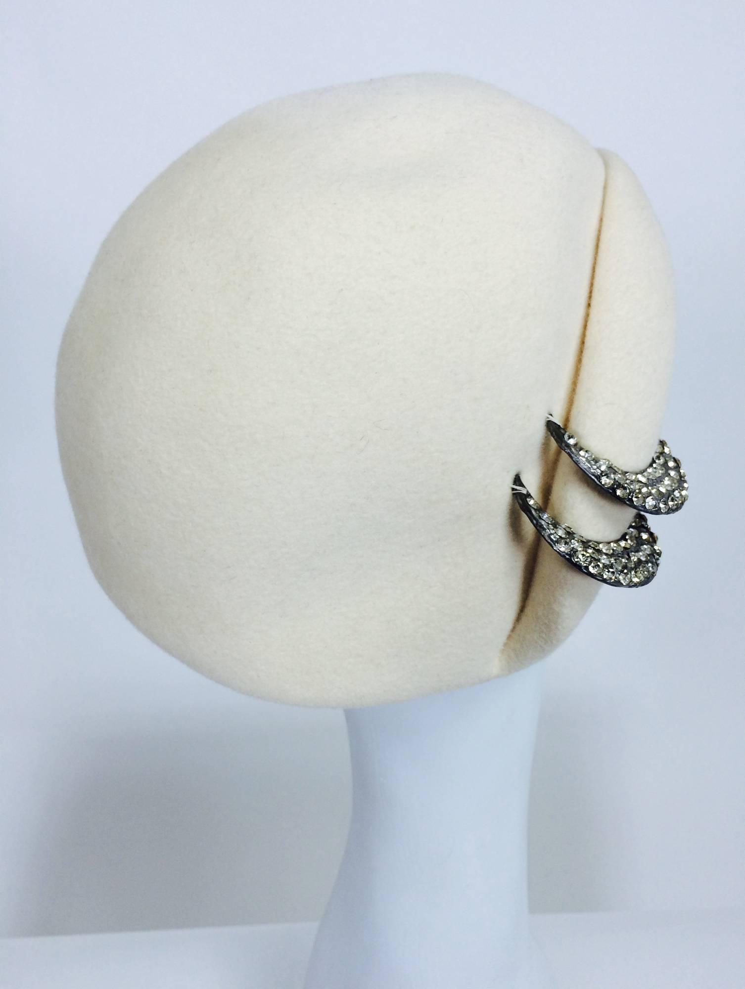 From the 1960s a cream wool cocktail hat with rhinestone trim...side rolled brim...fabric is marked Halson...Labeled Halston....

Measurements are:
21 1/4