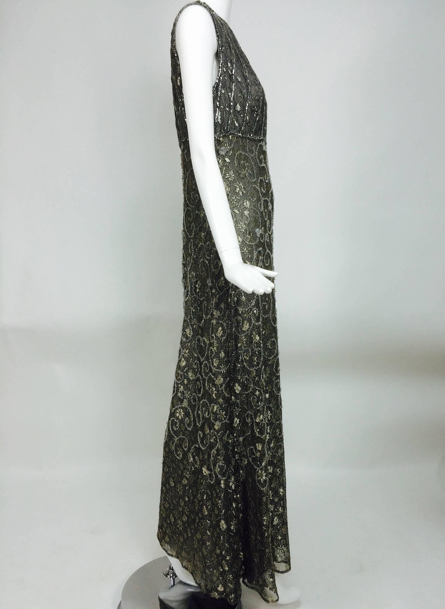 Badgley Mischka embroidered & beaded silver metallic lace gown...Jewel neckline fitted high waist bodice gown, long skirt is fitted through the torso and flares at the hem...The fabric is beautiful, silver lace that is embroidered in crystal beaded