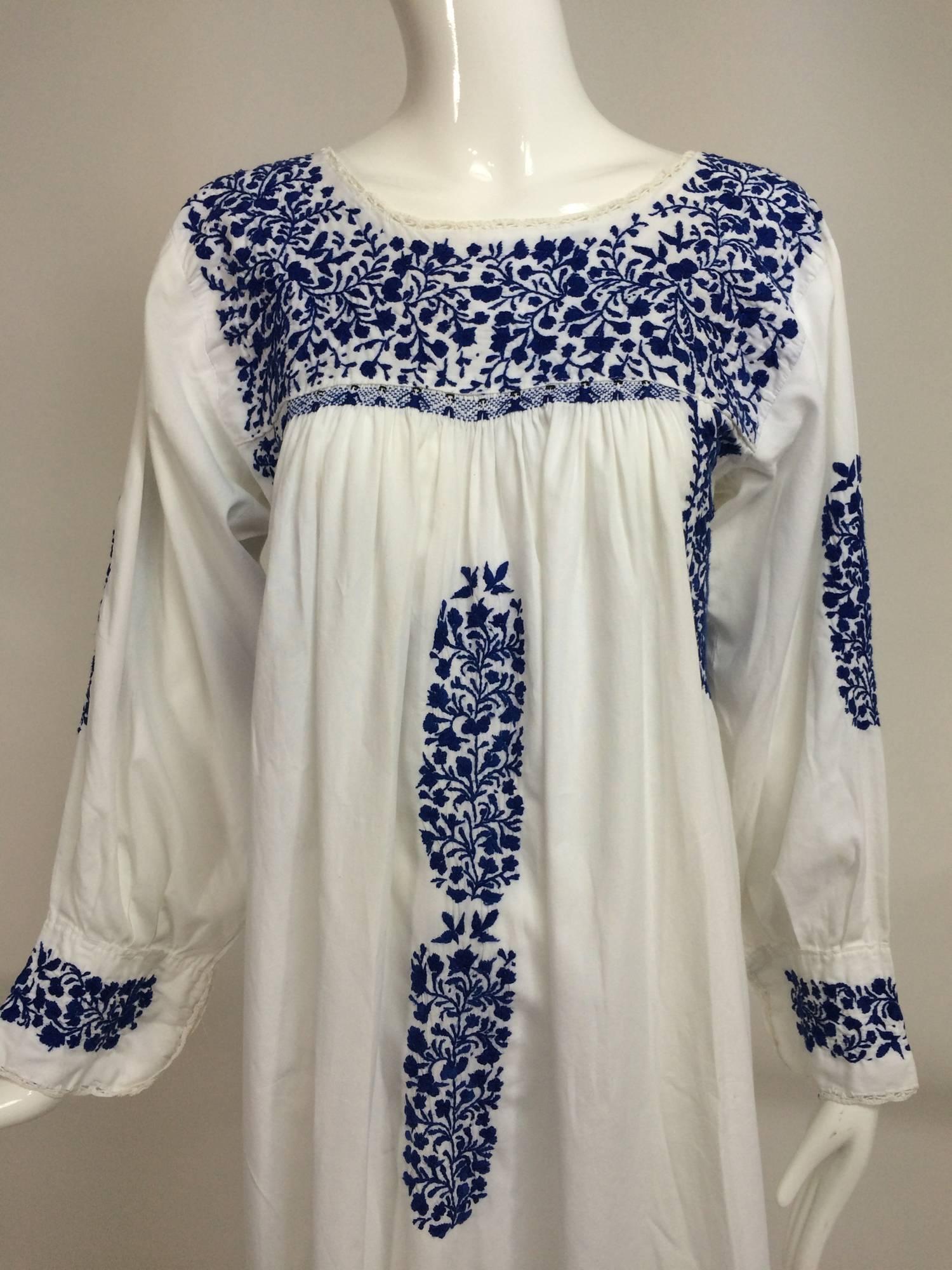 1960s blue and white cotton embroidered peasant dress from Oaxaca, Mexico an area know for it's indigenous cultures and native handicrafts...White cotton dress with long sleeves, the yoke, dress front, underarms and cuffs are hand embroidered in