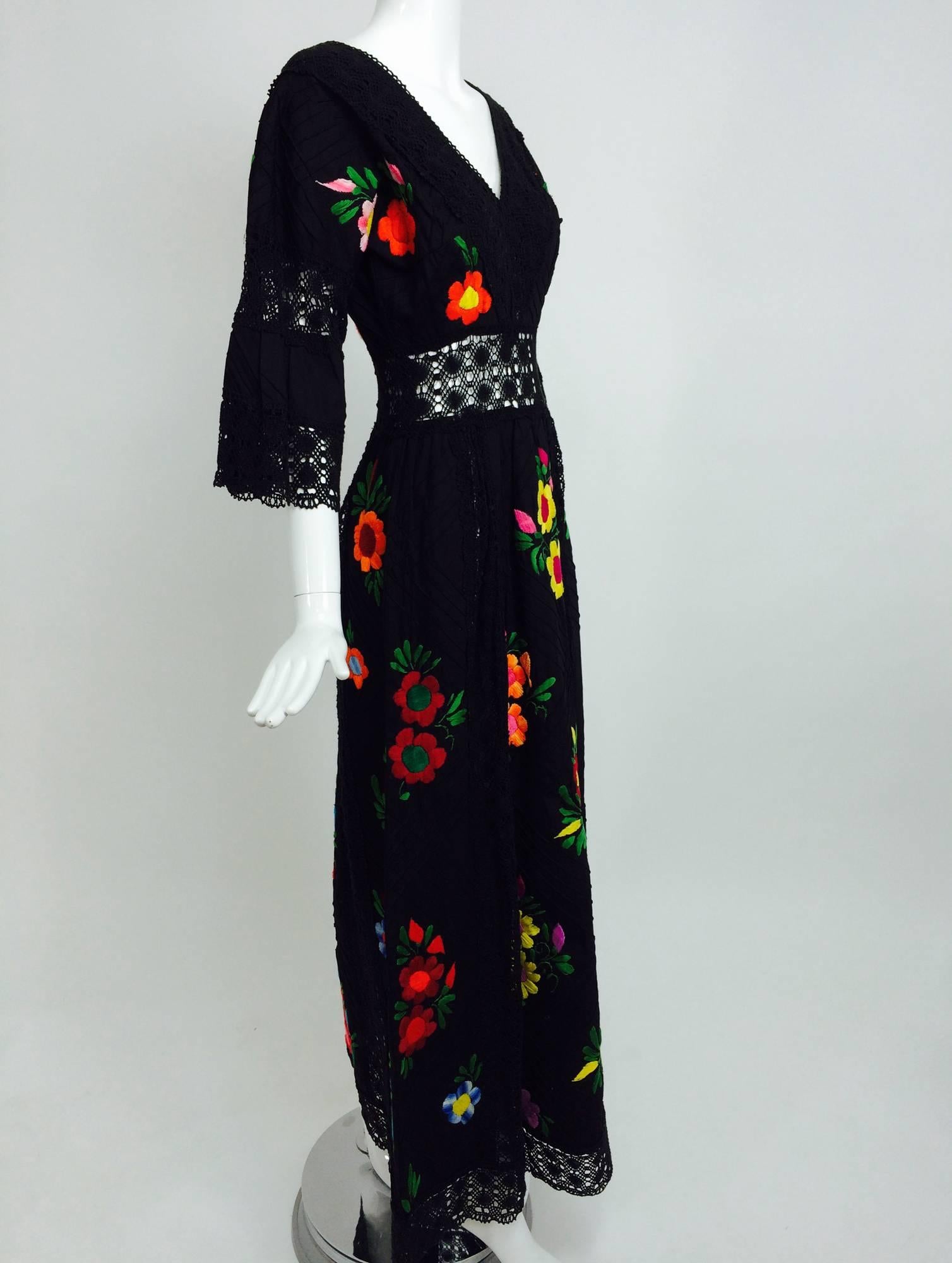 Vintage colourfully embroidered black cotton & lace Mexican maxi dress 1970s...Black tucked cotton dress with bright cotton embroidered flowers scattered throughout...Plunge neckline trimmed in wide black crochet lace...The dress has a wide band of