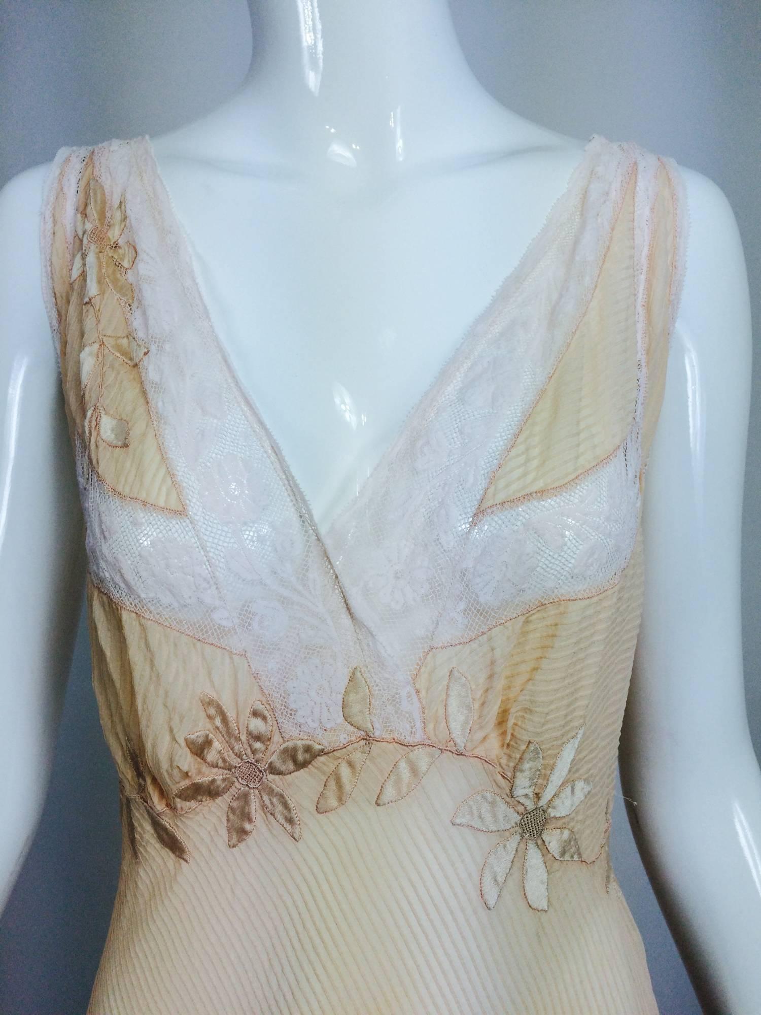 Hand made pale peach micro pleated bias cut silk chiffon night gown from the 1930s...Entirely hand stitched...The deep neckline and bust is trimmed in white Valenciennes lace...Beautiful appliques of silk satin in the shape of flowers wind around