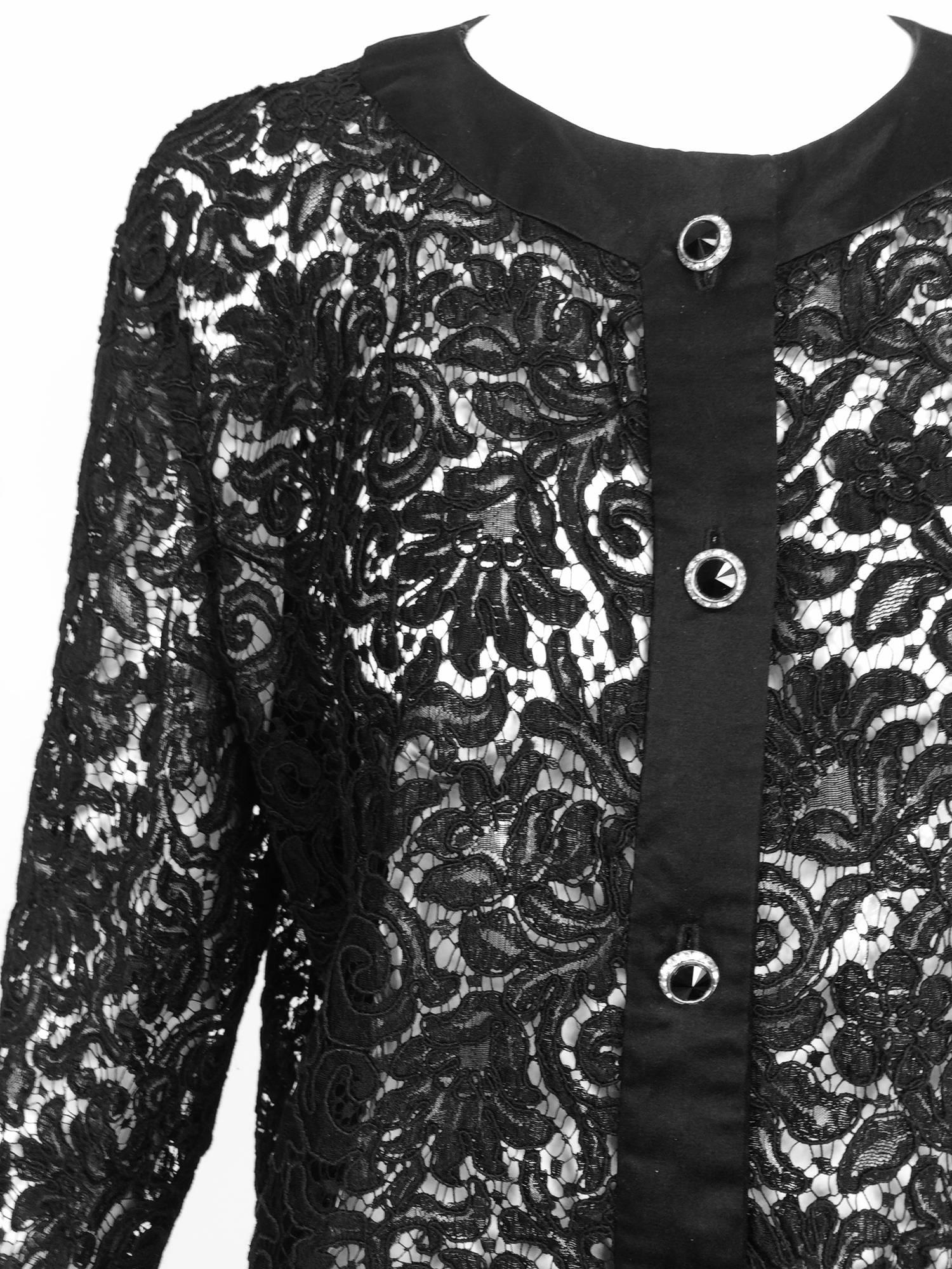 Beautifully made black Guipure lace coat from the 1990s...Classic Chanel style, black satin facings, round neckline, button front, the cuffs have satin trim with jewel buttons...The coat closes at the front with jewel buttons (black stone centers
