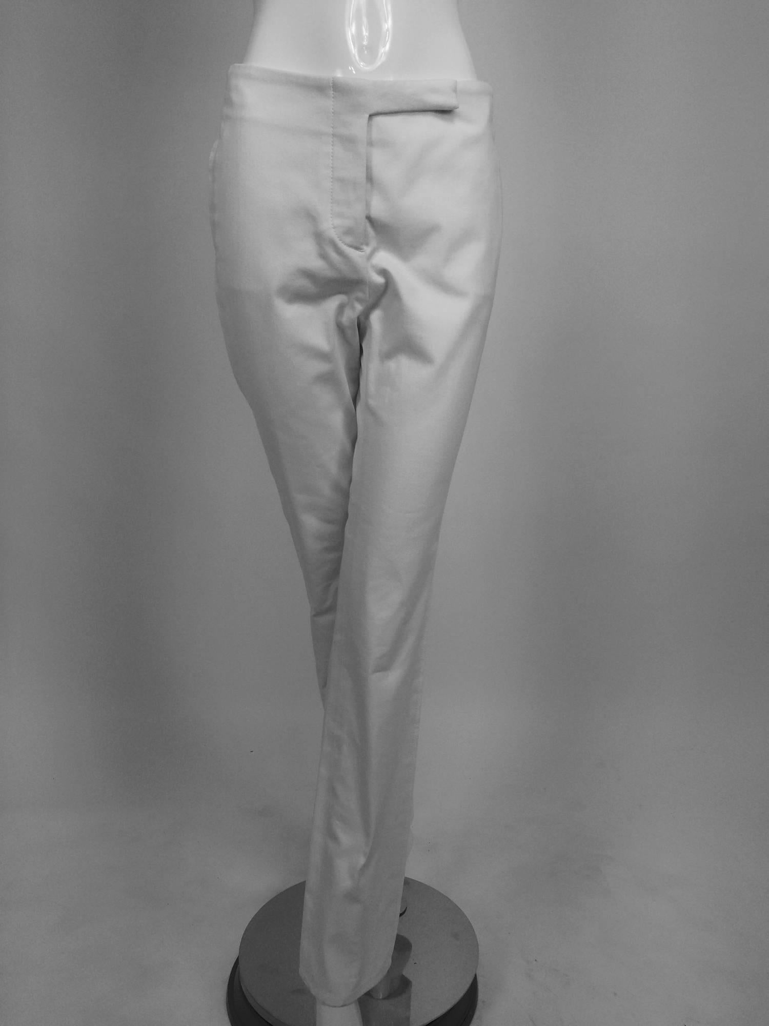 Chanel white cotton twill trousers...Fly front with hidden waist closure...Flat front with faux side pockets...The waist back has an adjustable silver buckle...The legs taper slightly at the hem...Unlined...Marked size 38, fits like a size
