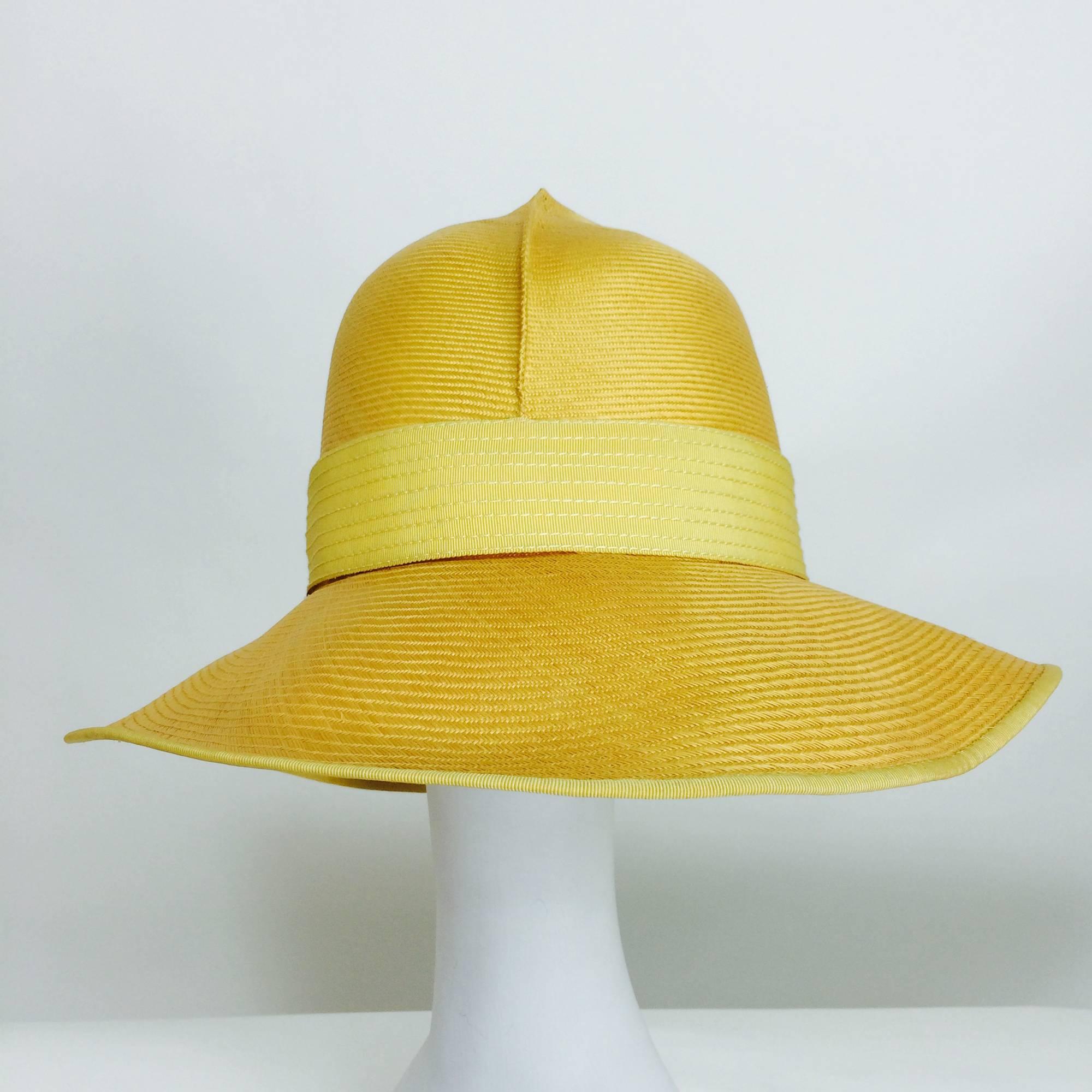 This hat definitely has a 1920s cloche feel!  Beautiful golden yellow fine woven straw, deep crown with a pleat at the front...The brim turns down...Wide top stitched yellow gros grain ribbon band outside...Unworn...James Galanos, from the
