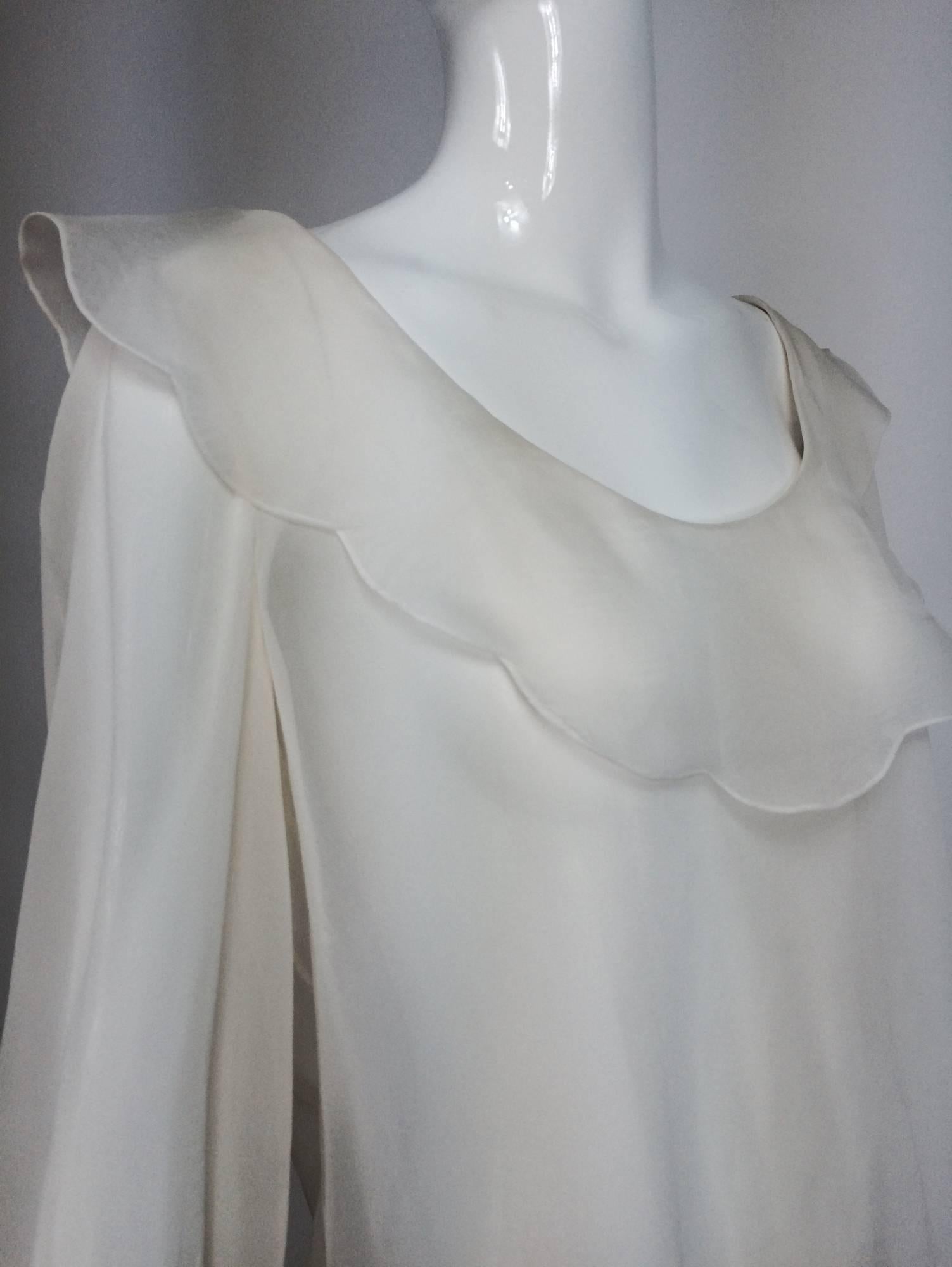 Valentino off white silk chiffon poet blouse large...Beautiful & romantic...Low round neckline has a scalloped organza collar...Long full sleeves with organza ruffle cuffs...Buttons up the back...Unlined

In excellent wearable condition... All our