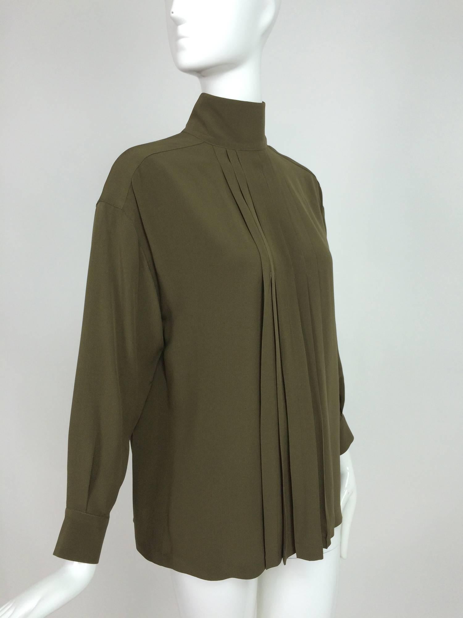 Chanel moss green silk crepe button back blouse 38...Rich moss/olive green silk crepe blouse with open pleats at center front and back...Stand up collar, long sleeves with gold Chanel button cuffs, blouse closes at the back with gold Chanel