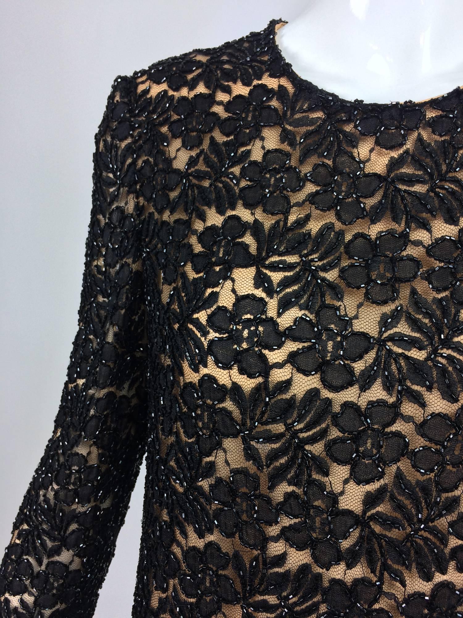 Mod style shift dress from the early 1960s...Black floral lace is beaded in black glass beads...Jewel neckline, long sleeves slightly A line dress...Lined in nude organza...The dress closes at the back with a zipper and hook and eye...Custom