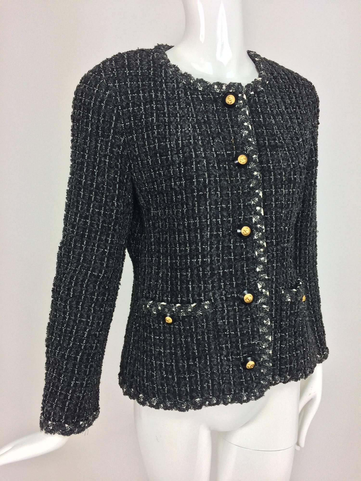 Chanel classic black grey cream tweed 2 pocket jacket 40 1993A...Jewel neck jacket has contrasting trim...slightly tapered at the waist...Wool and cotton chenille tweed...Hip front pockets with gold and black Chanel logo buttons...Fully lined in
