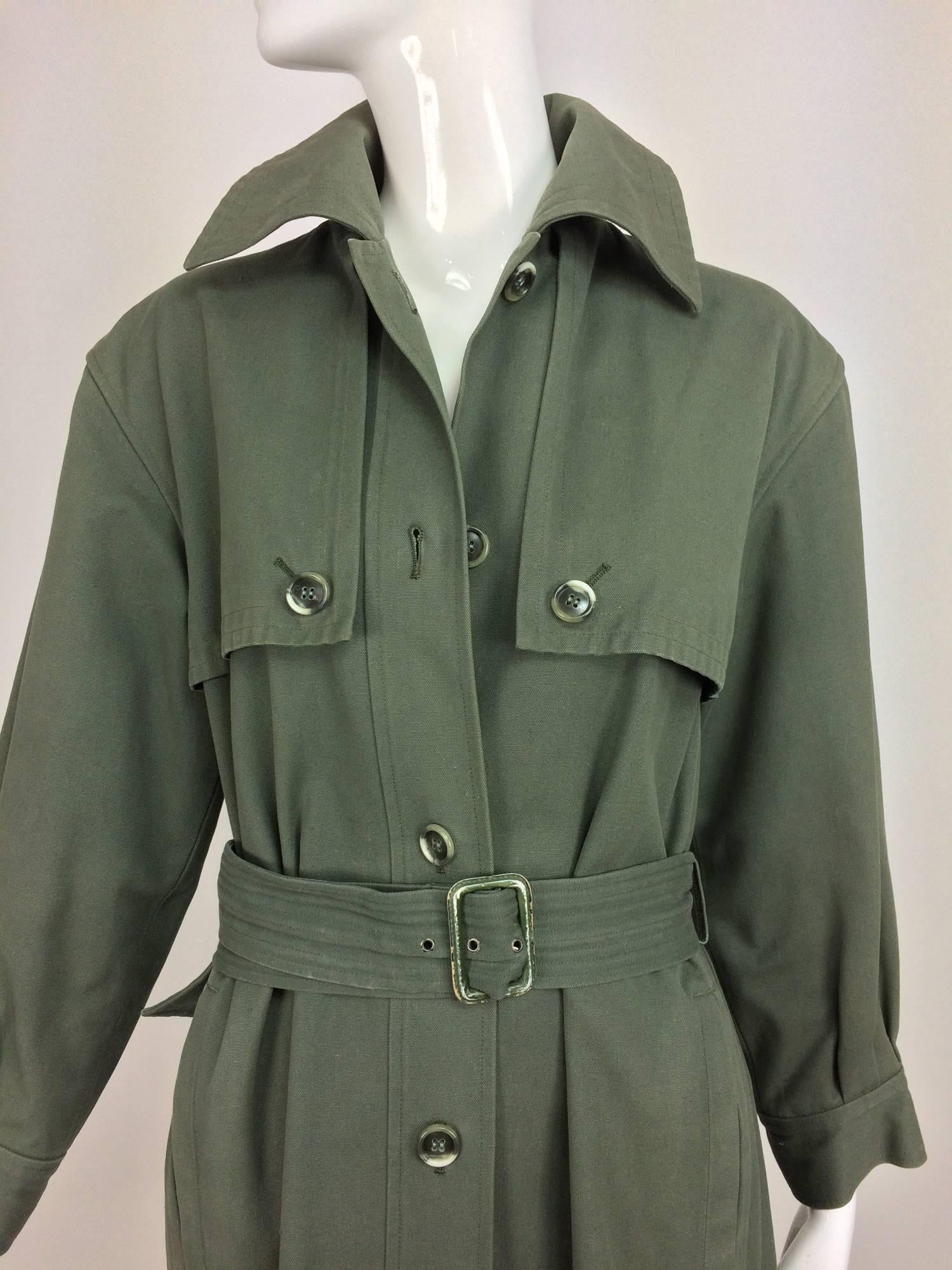Vintage rare Yves St Laurent military green canvas trench coat 1970s...Military green canvas trench coat is a rare find from the 1970s...Single breasted coat has button front storm flap and deep back storm flap...Long sleeves are gathered into