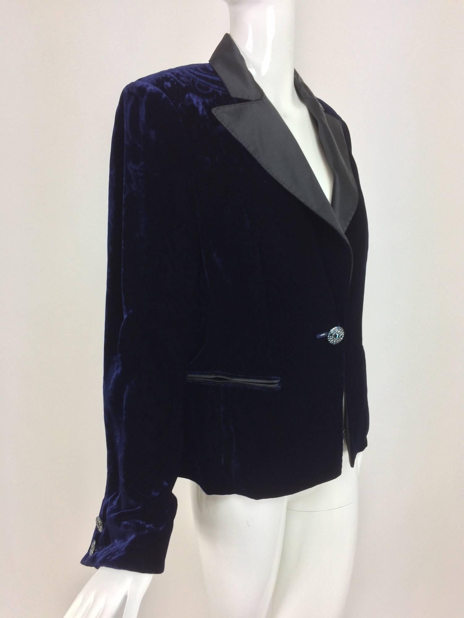 Feraud ink blue embossed velvet tuxedo style jacket with notched black satin lapels that have top stitched edge...Long sleeves flare at the cuffs and have two jewel buttons each...Single jewel button closure at the waist...Black satin trimmed besom