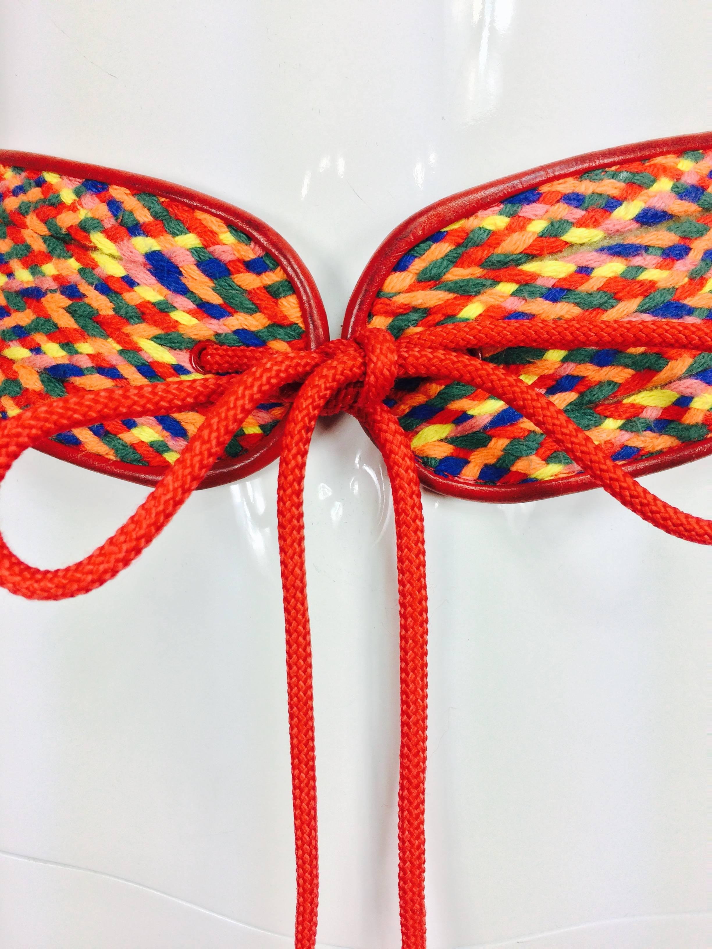 Vintage Yves Saint Laurent woven coloured cord and leather belt 1960s...Wide woven cord in red, orange, green and yellow trimmed with red leather...Closes at the front with long red cord ties each end has a red wooden bead...Marked size B