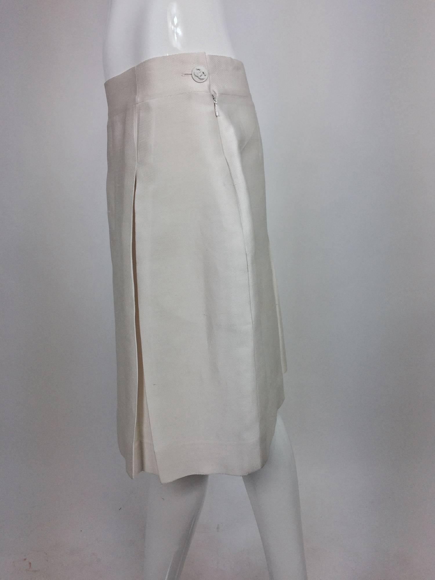 Chanel off white silk cotton pique box pleated skirt 2009...Stitched down pleats at the front and a single inverted pleat at the back...Closes at the side with a zipper and button at the waist side...On seam side pockets...Fully lined in white