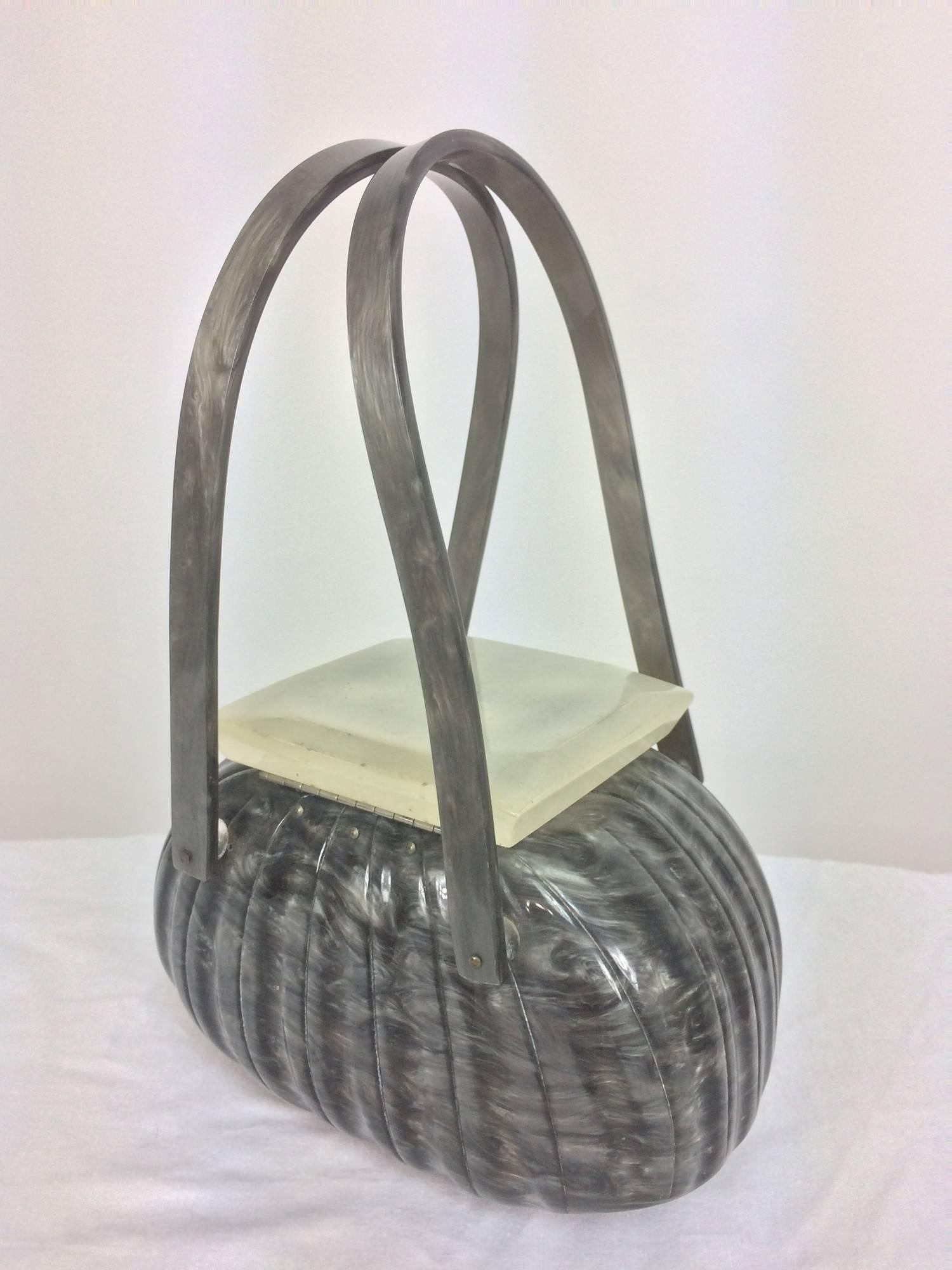 Vintage Llewellyn grey pearlized Lucite double handle handbag 1950s...Oval shape bag with fluted design, double handles...The square lift top is frosted opaque Lucite with a carved design of four leaves...Marked Llewellyn in script on the inside