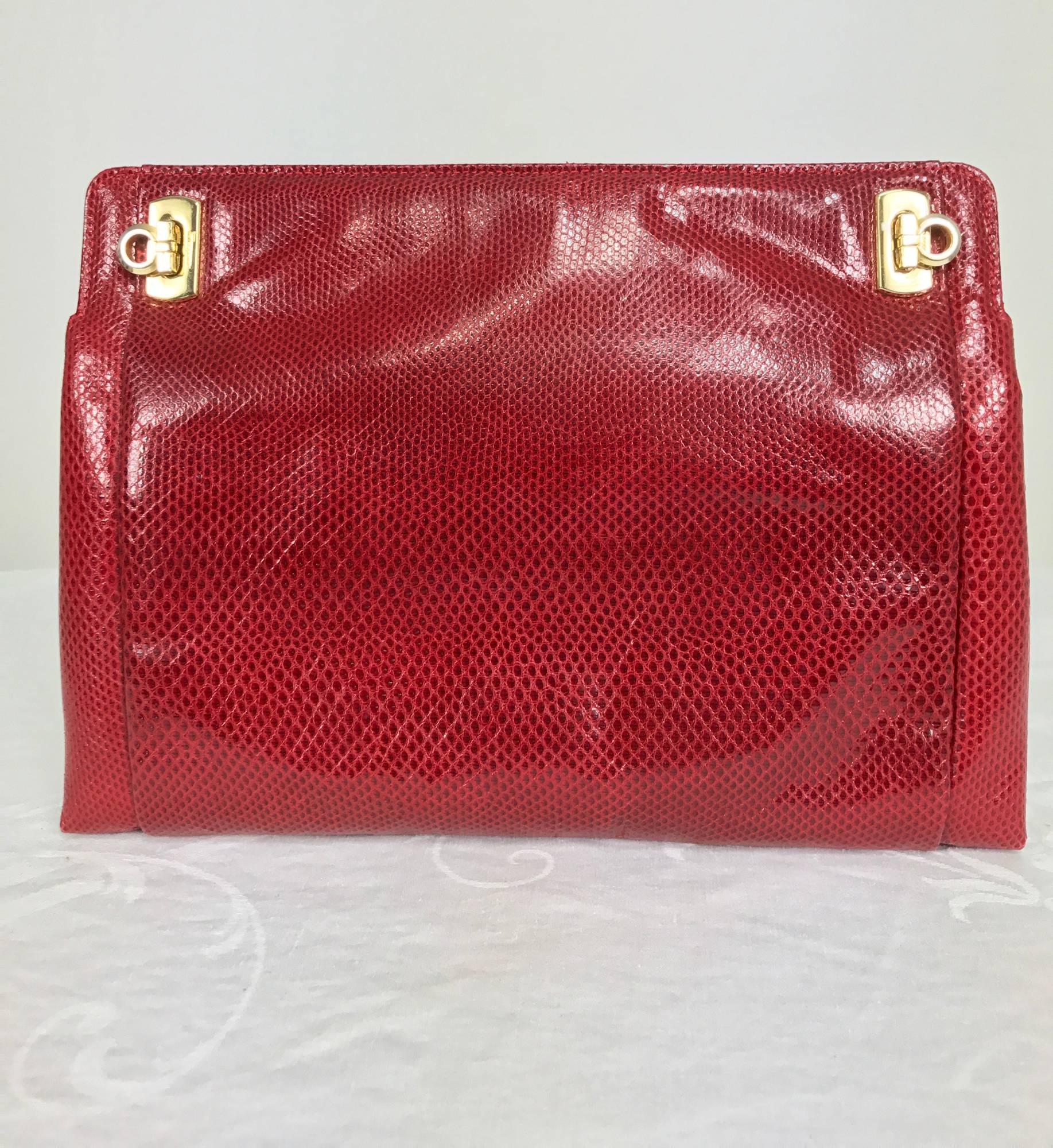 Vintage Ferragamo red lizard clutch cross body handbag 1980s...Cherry red lizard bag has gold hardware closes with 2 turn locks at the front top of bag...Long narrow shoulder strap has gold clasps to use or remove...Lined inside in black with a
