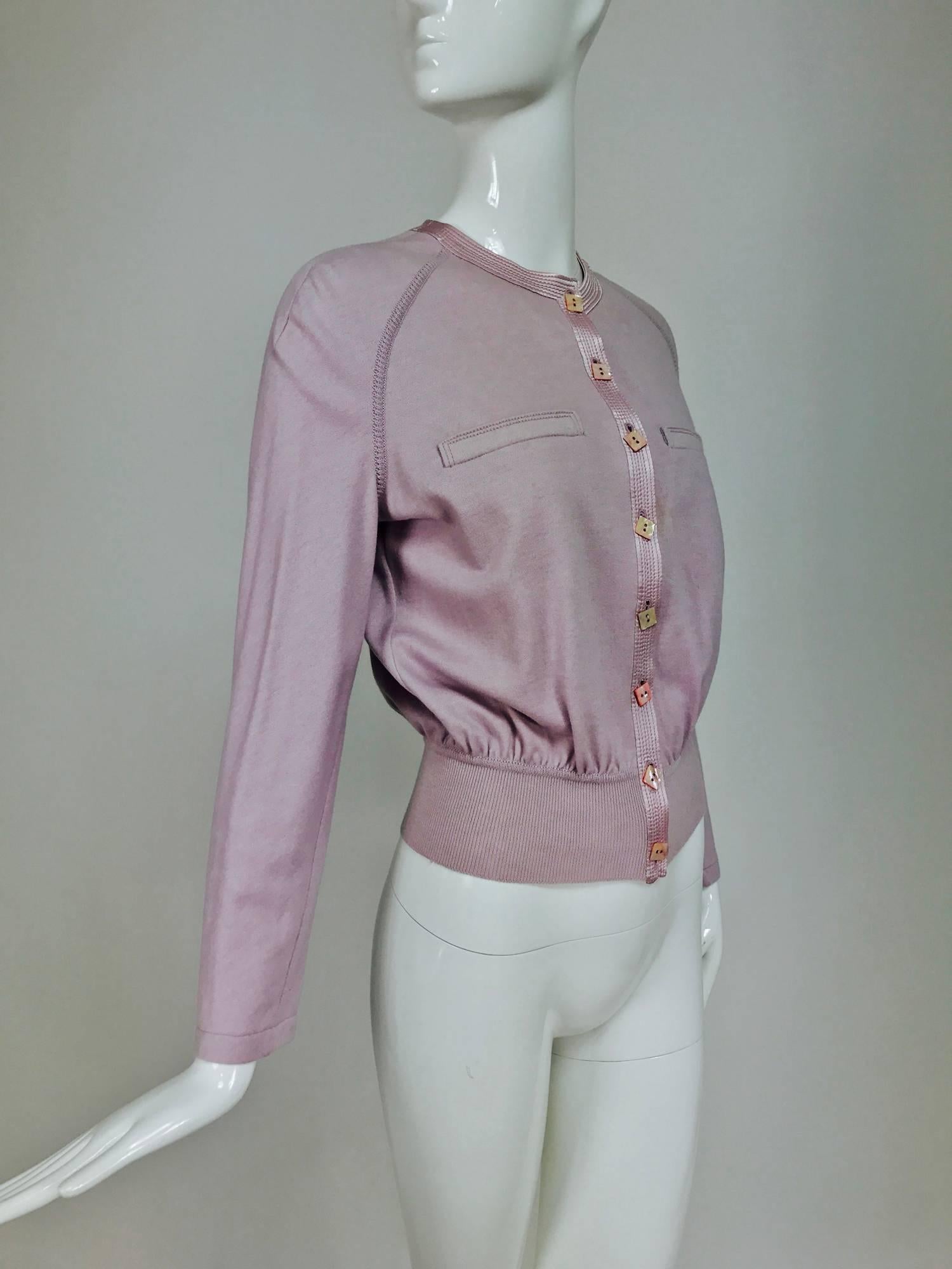 Valentino soft cashmere and wool knit sweater with satin trim from the 1980s. Raglan sleeves with finished cuff. Closes at the front with a top stitched satin band and beautiful square pink mother of pearl buttons. Deep ribbed hem. Unlined. two