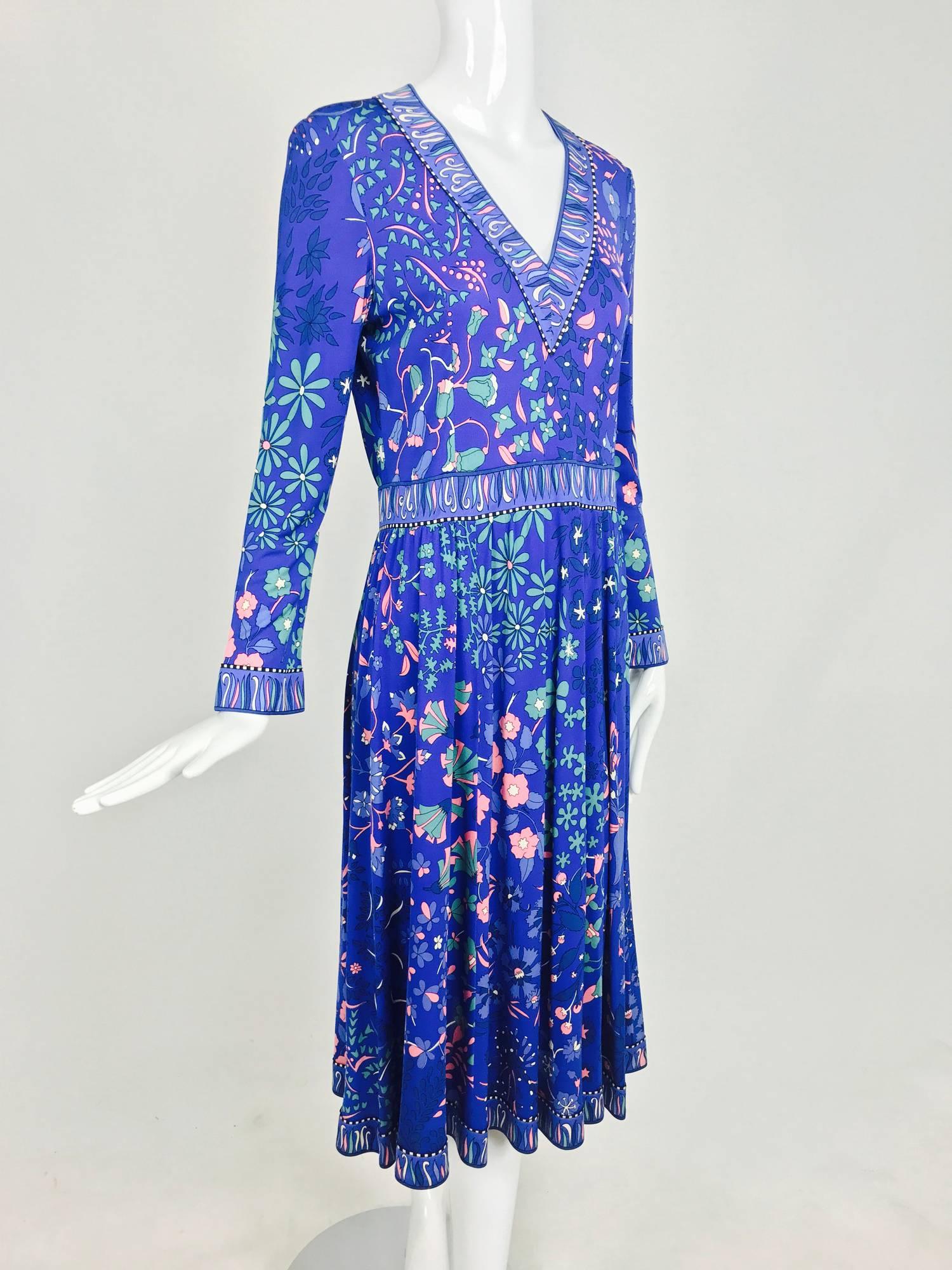 Bessi silk jersey dress from the 1970s...Banded blue V neckline, long sleeves with banded cuffs...Banded waist and lightly gathered skirt that flares at the hem...Unlined...Closes at the back with a zipper and hook and eye...The print is beautiful