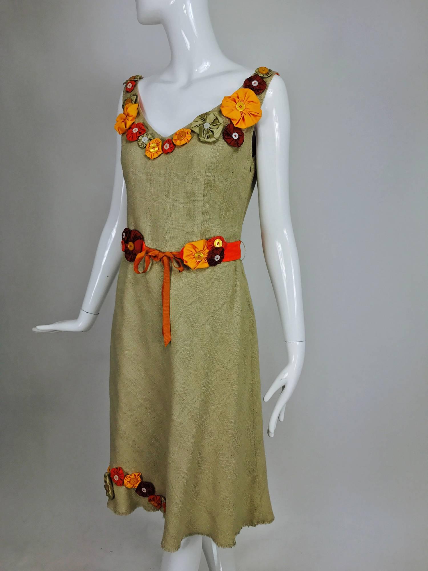 Moschino natural mid weight silk linen sleeveless shift dress with scoop neckline trimmed with brightly coloured fabric flowers with button centers...A line skirt has flower appliques at the skirt side front, the hem is a raw edge narrow