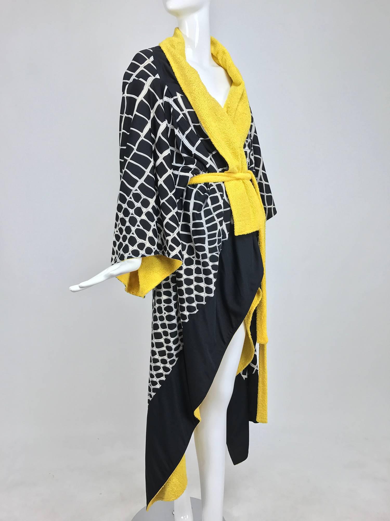 This unique coat is made from black and white silky fabric that is lined in bright yellow terrycloth...The coat is constructed of a square of fabric that is formed on the bias with attached kimono arms and a draped hem...Shawl collar and terry self