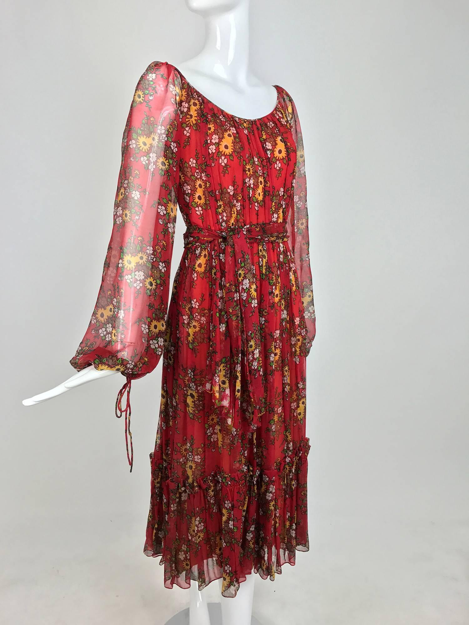 Bohemian style peasant dress from the 1970s, labeled House of Arts. Sheer silk in dark red with a floral print, scoop neckline, raglan sleeves with tie cuffs. Full gathered skirt with a deep ruffle hemline. Together with the original self tie sash.
