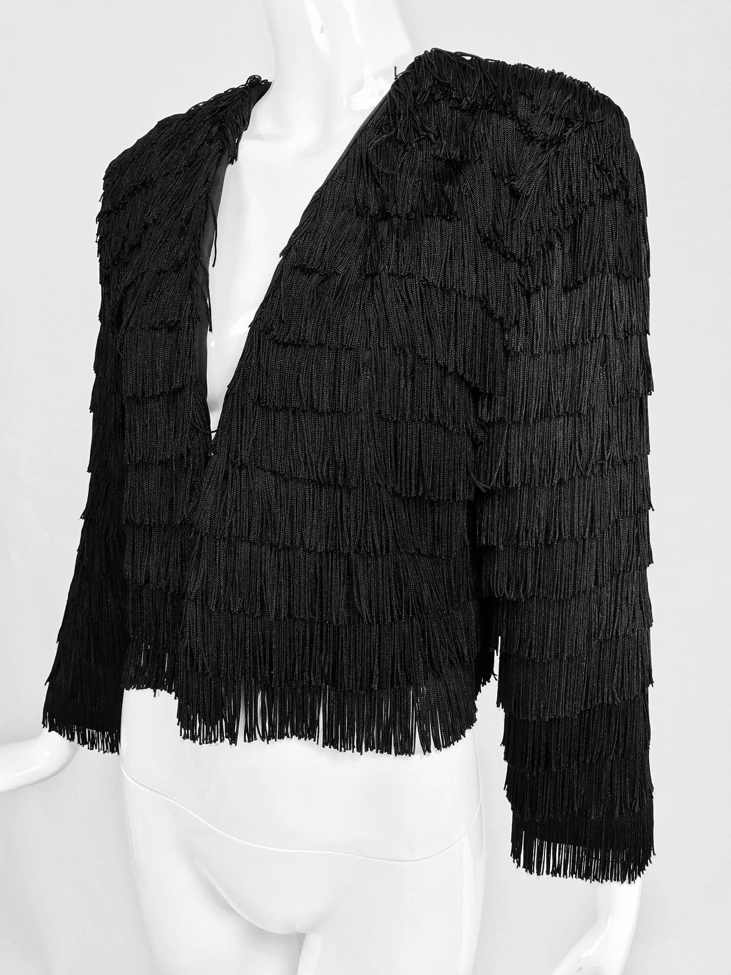 Dramatic Black crepe totally fringed jacket from the early 1980s...Open front jacket with long sleeves is covered in horizontal, row after row, black fringe...Extremely well made and in excellent barely worn condition, the label has been