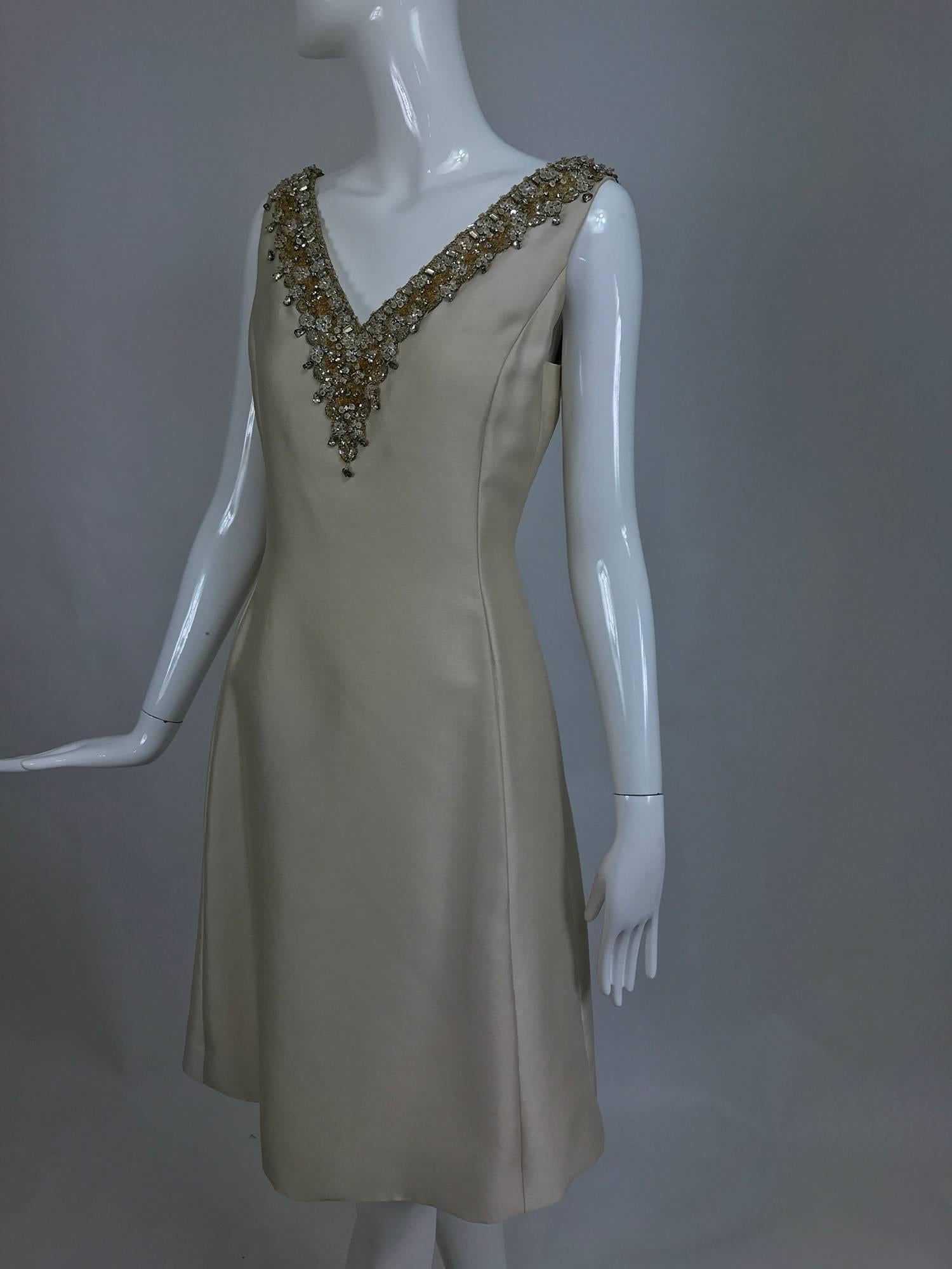 Vintage Malcolm Starr jeweled V neck lustrous cream silk dress from the early 1960s...Princess seam dress has a deep V neckline that is heavily beaded and has crystal set rhinestone trims...Beautiful lustrous mid weight silk dress has front on seam