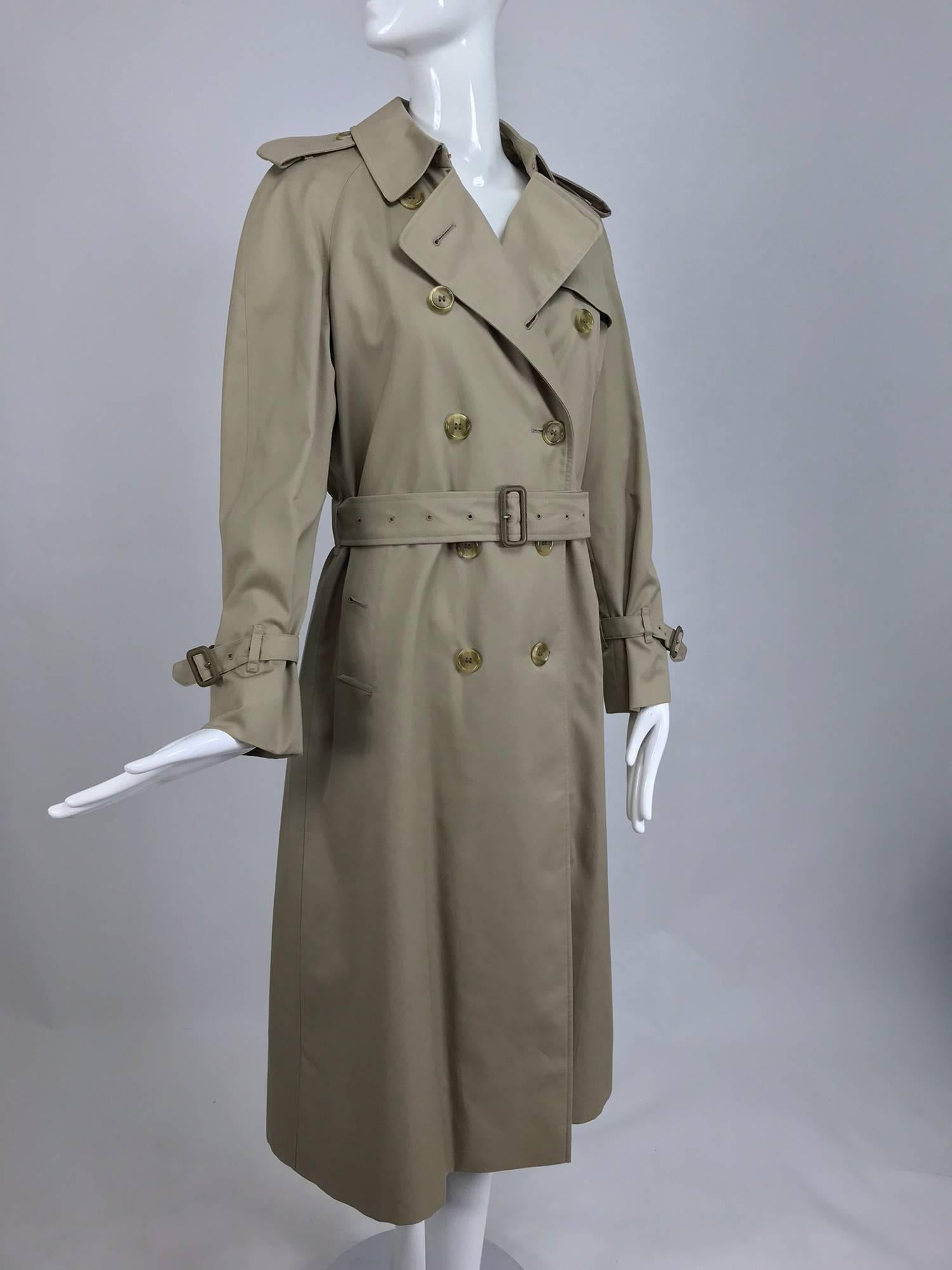 Burberrys classic tan poplin trench coat with zip out removable nova check wool lining...All the classic trench coat details are here, epaulets, storm flap, self belt, pocket flaps, raglan sleeves sleeve buckle bands, deep back vent with button