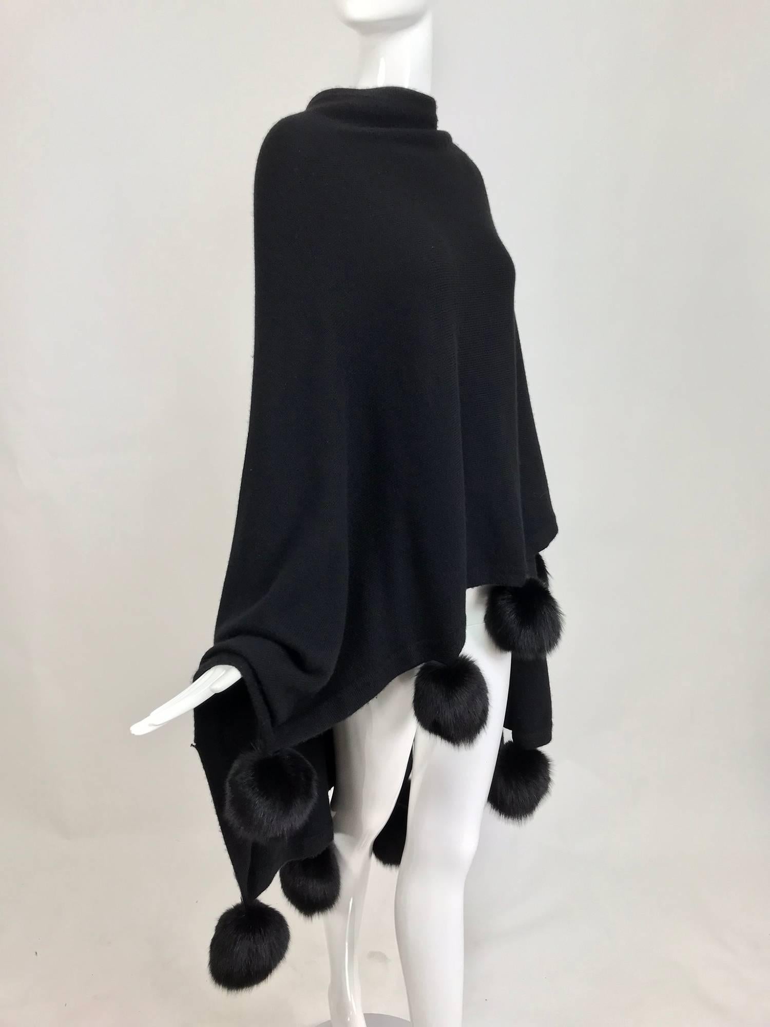 Black cashmere wool blend knit cape or wrap with black mink pom pom trims...Beautiful weight cape is perfect for day or evening...Some minor pilling...One size fits all...

In excellent wearable condition... All our clothing is dry cleaned and